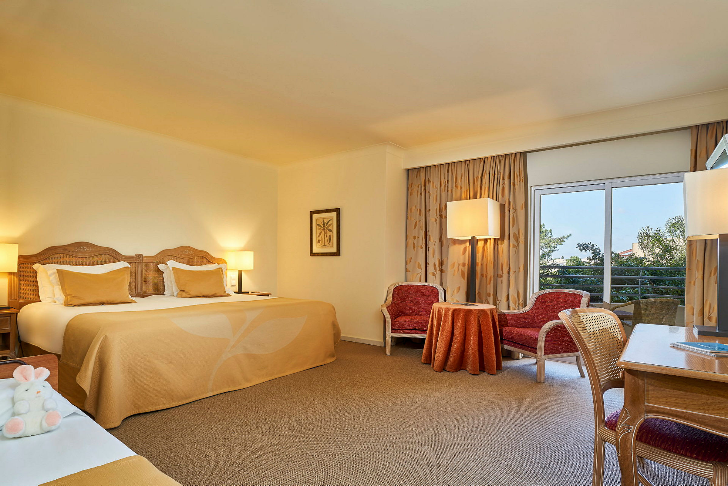 Bild av ett hotellrum med en stor säng, sittgrupp och fönster med gardiner. (AI-genererad text)