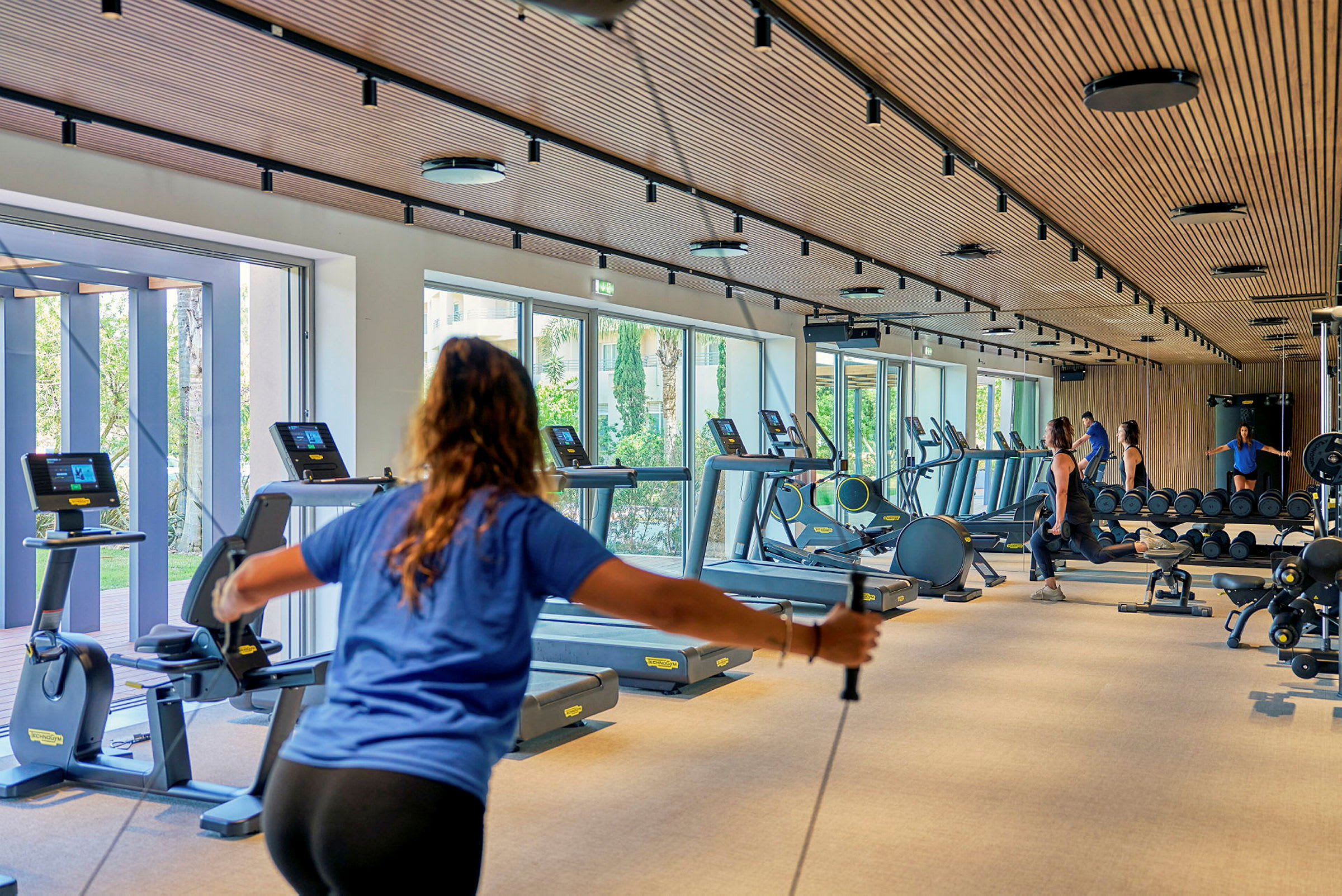 Gym med träningsutrustning och personer som tränar. (AI-genererad text)