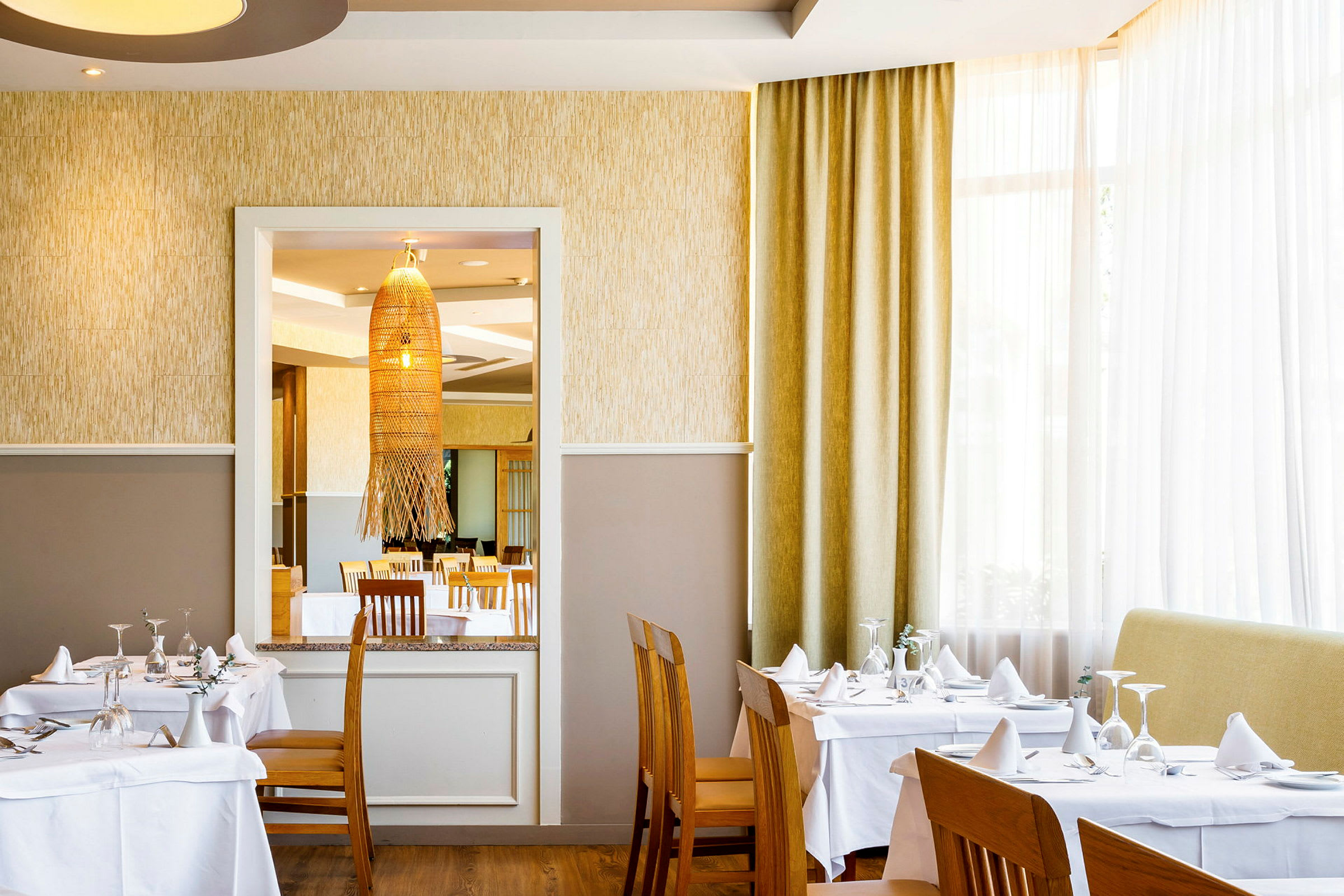 Interiör av en restaurang med dukade bord och stolar. (AI-genererad text)