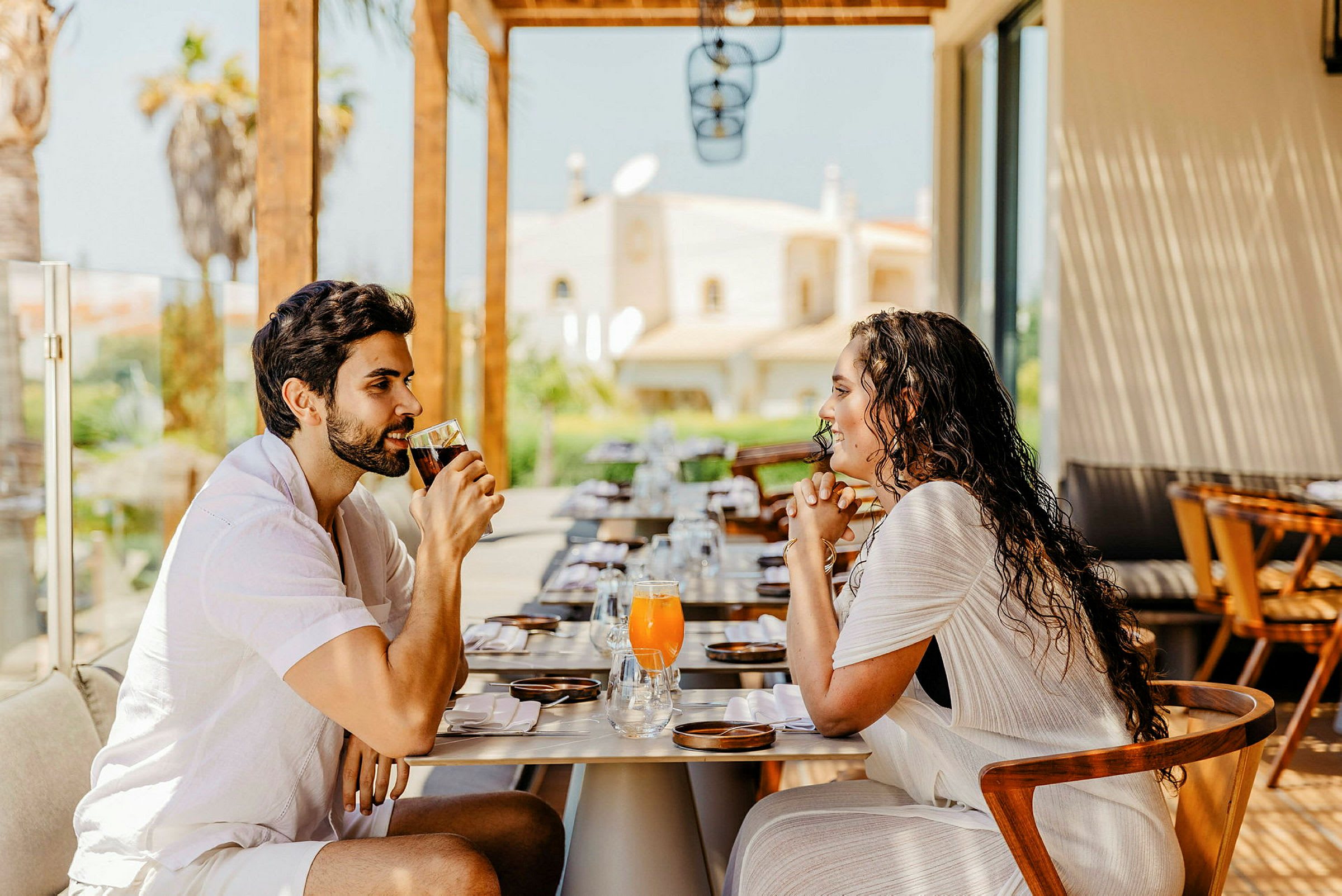 Två människor sitter vid ett dukat restaurangbord och dricker drycker. (AI-genererad text)