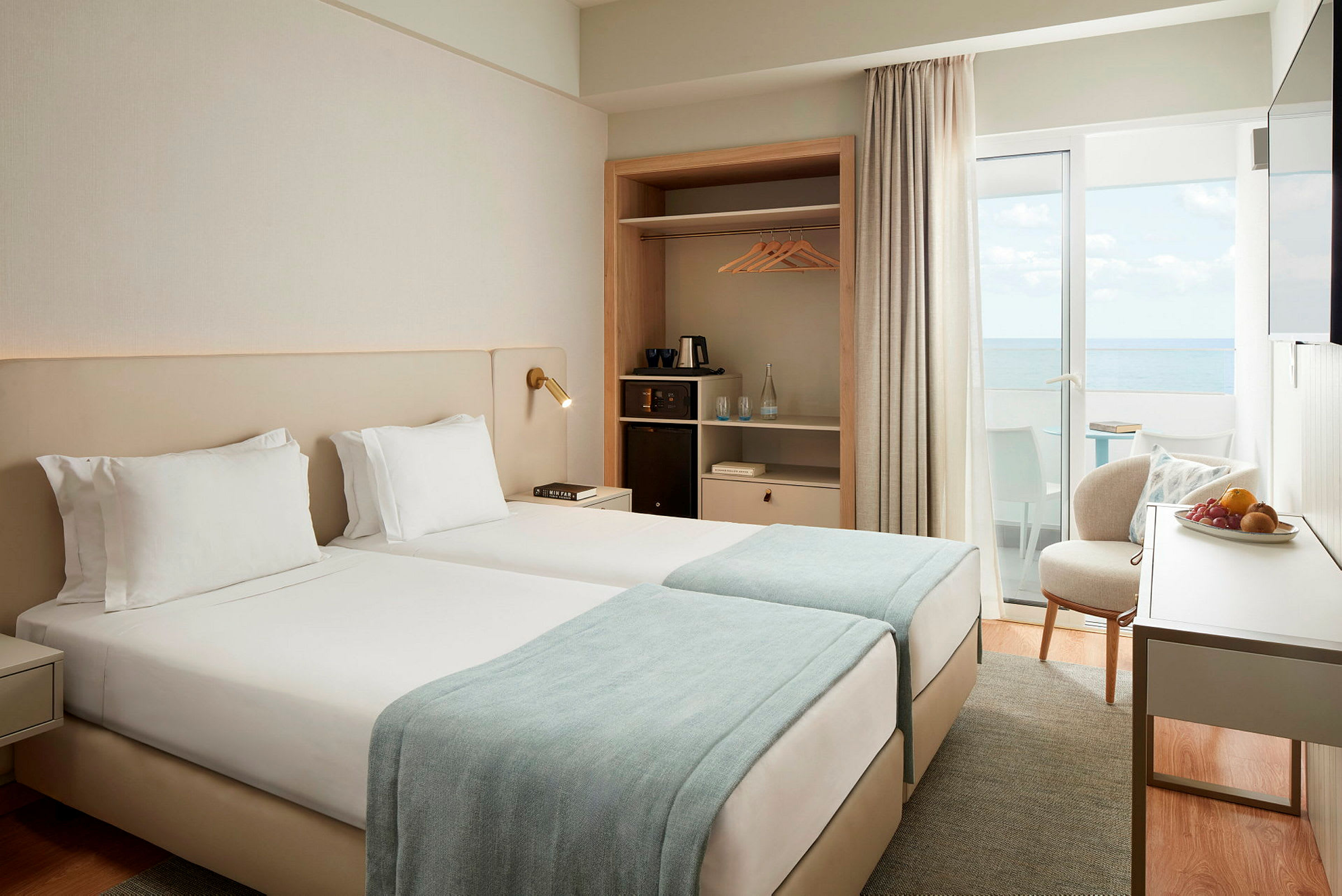 Ett hotellrum med två enkelsängar och havsutsikt. (AI-genererad text)