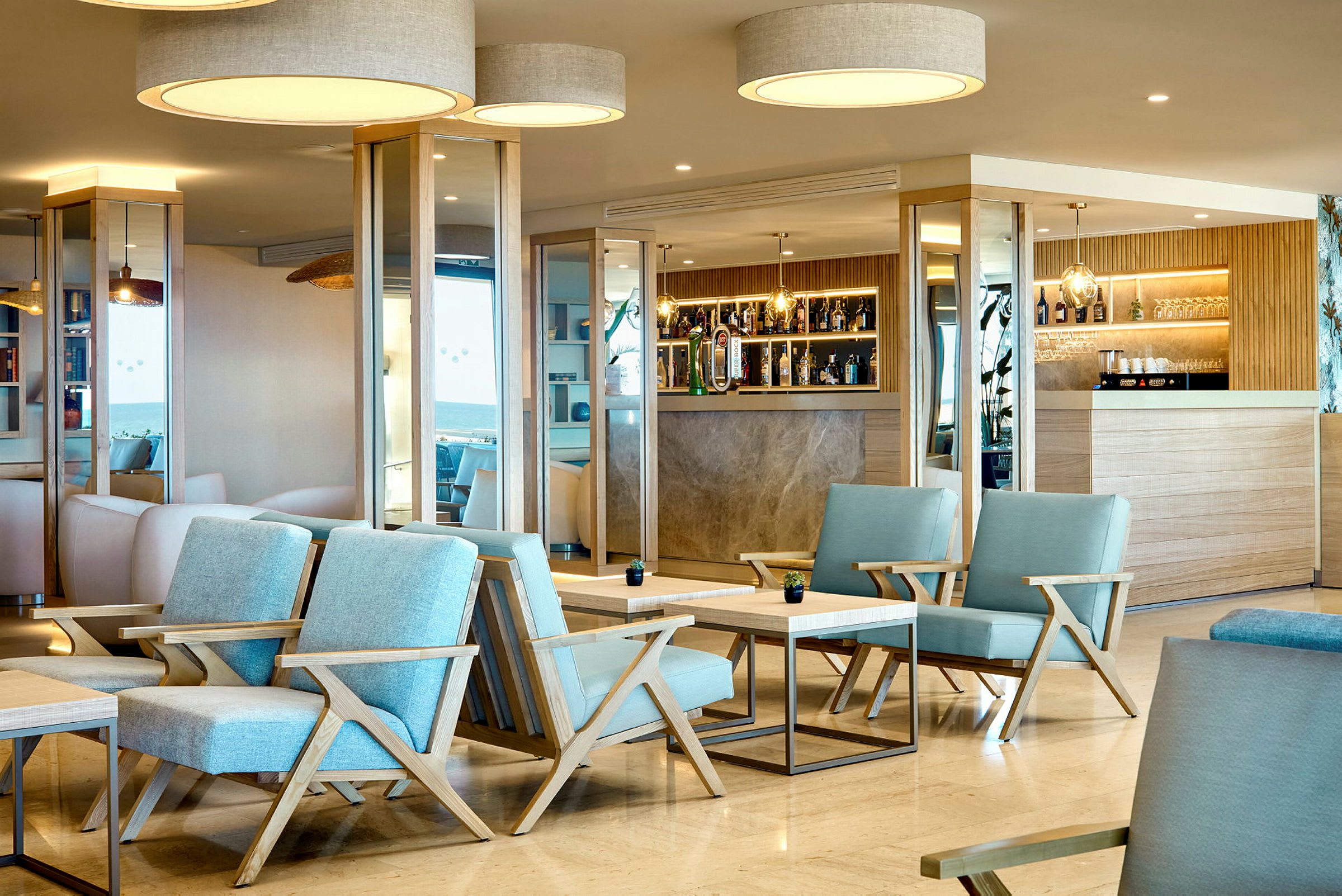 Ett modernt hotellbarområde med blå stolar och trädetaljer. (AI-genererad text)