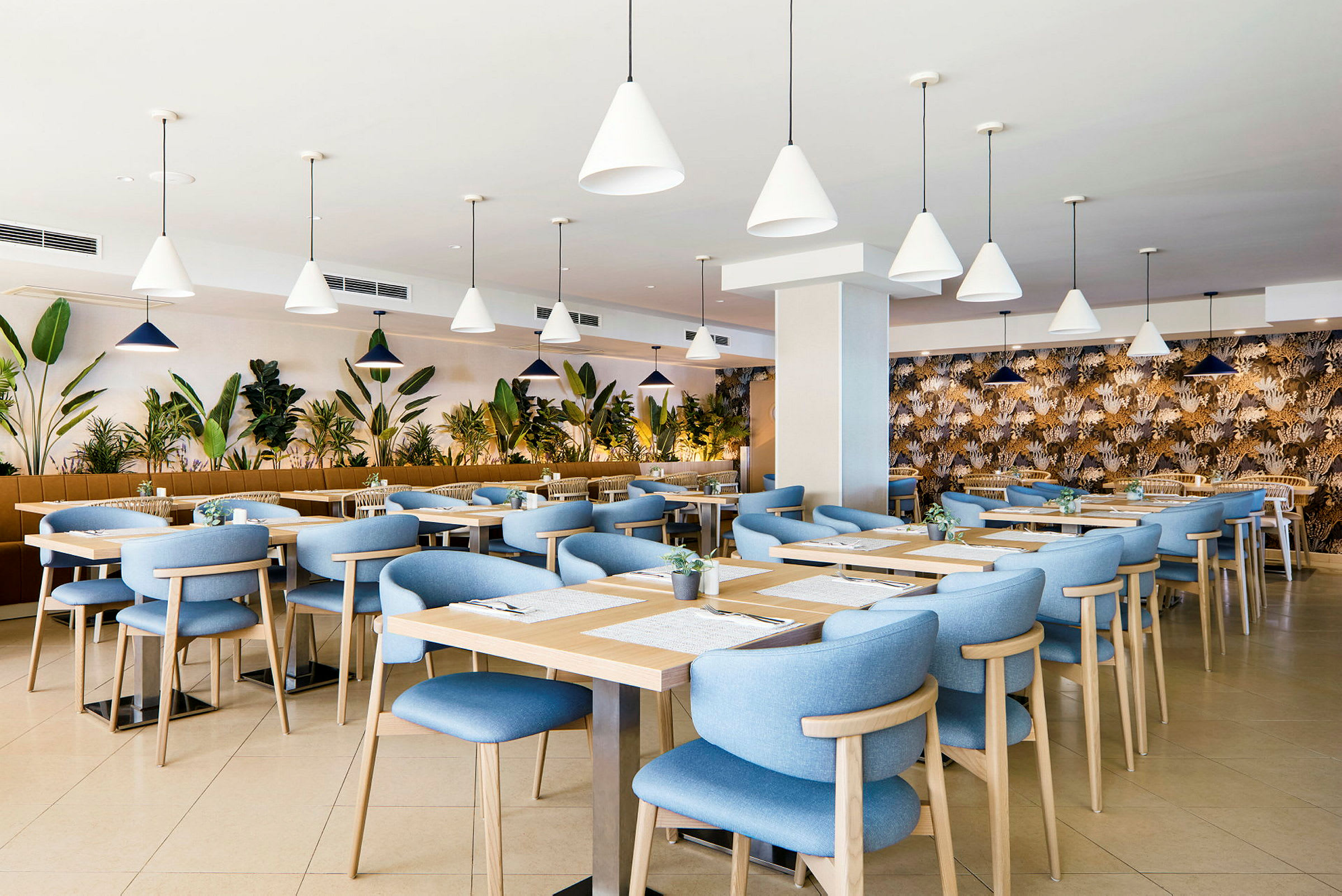Restaurang med blå stolar och träbord, omgiven av växter. (AI-genererad text)