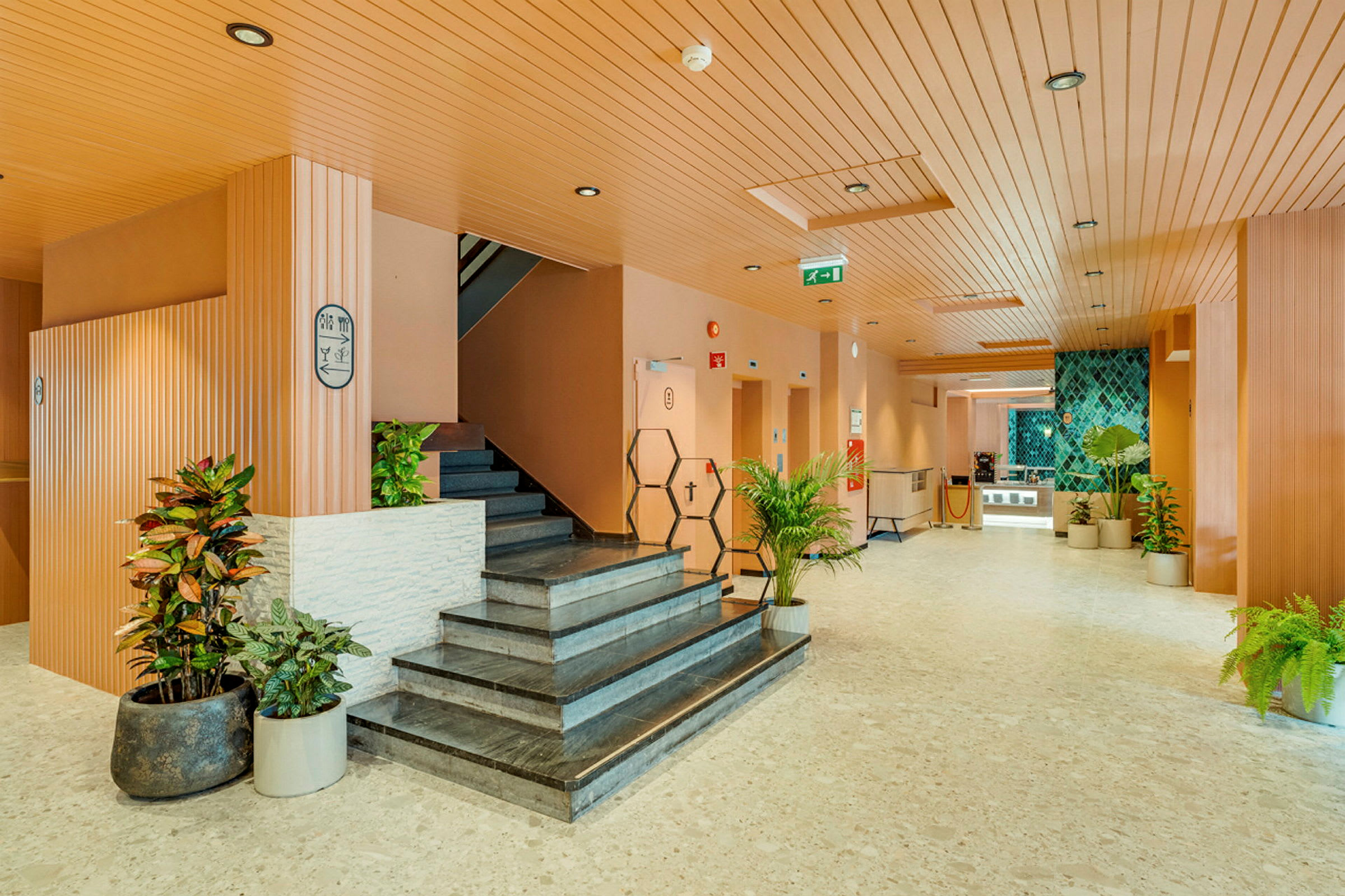 Hotellobby med trappa och dekorativa växter. (AI-genererad text)
