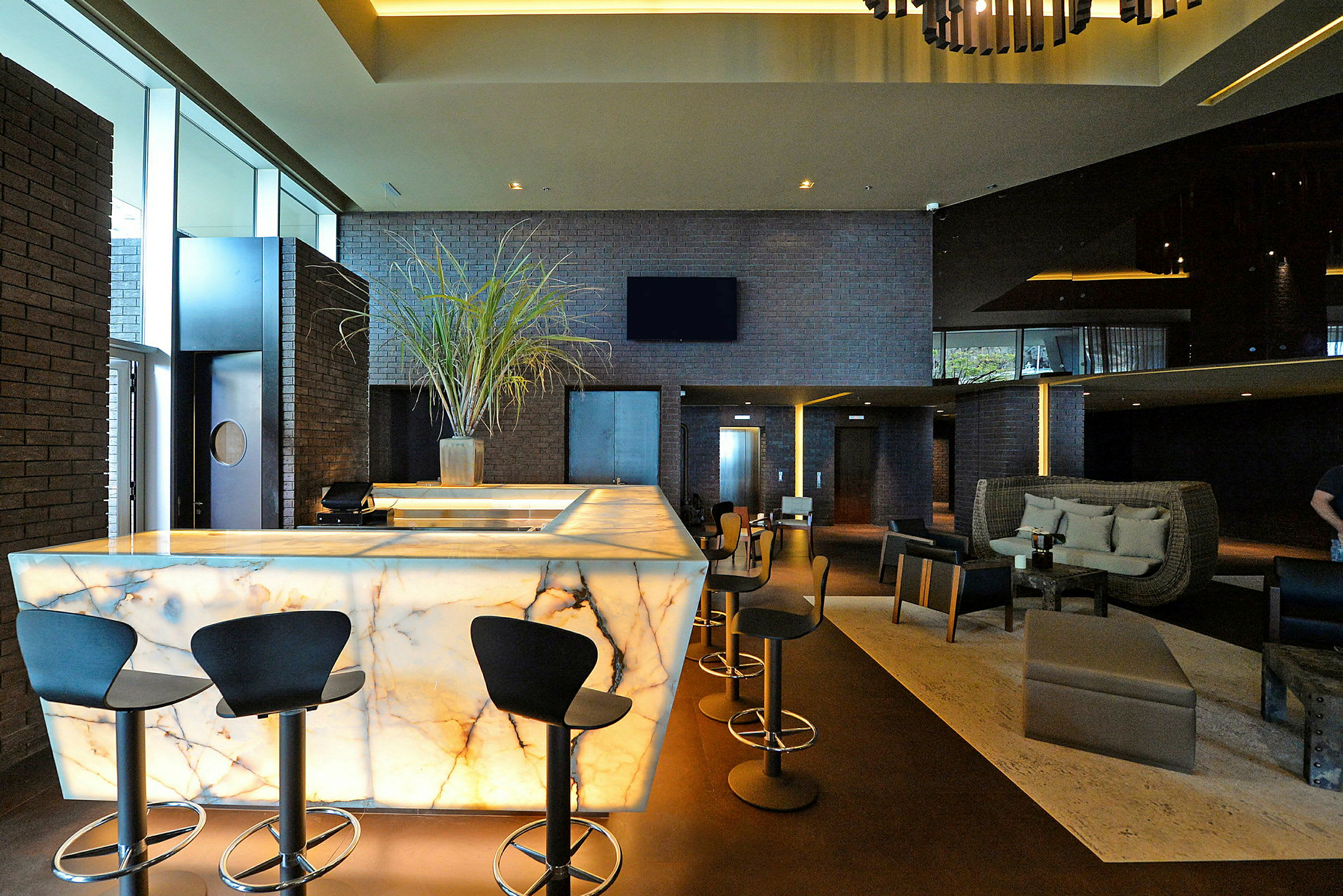 Bild av en modern hotellobby med en upplyst marmordisk och stilfull inredning. (AI-genererad text)