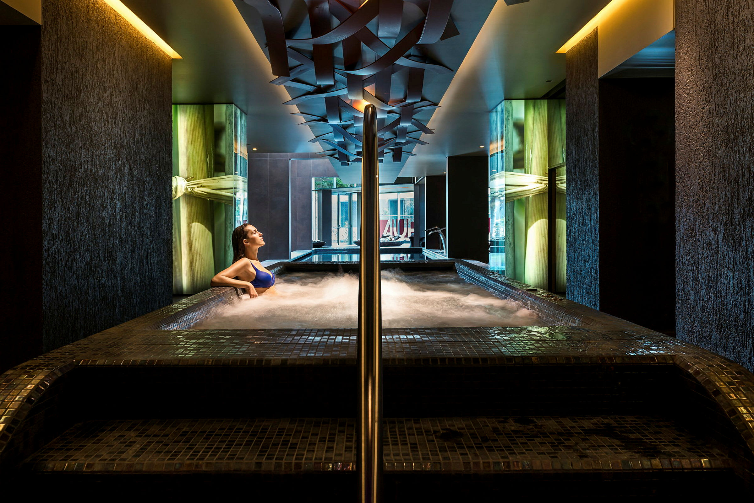 En person sitter i en bubbelpool i ett modernt spa. (AI-genererad text)
