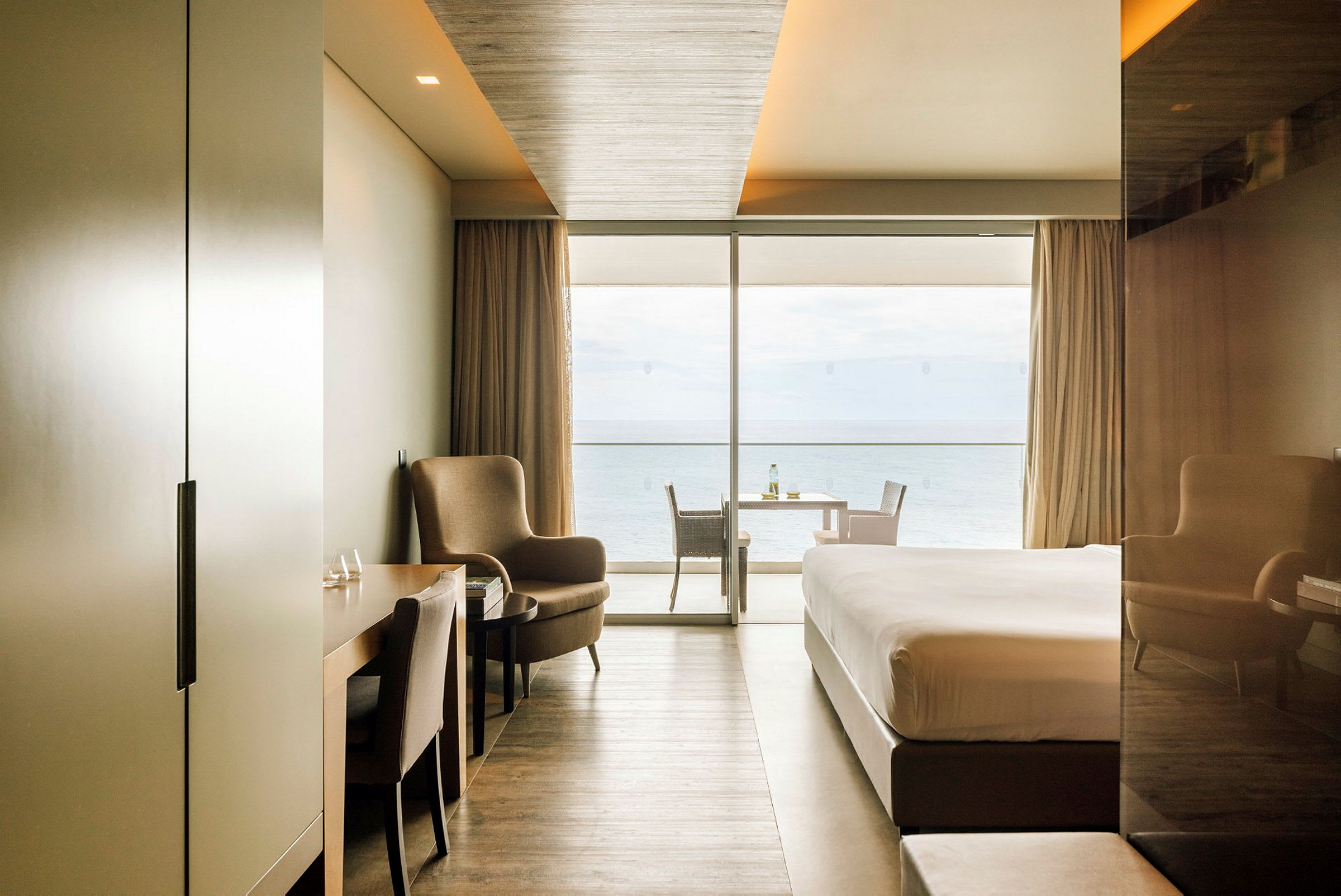 Modern hotellrum med havsutsikt genom stora fönster. (AI-genererad text)