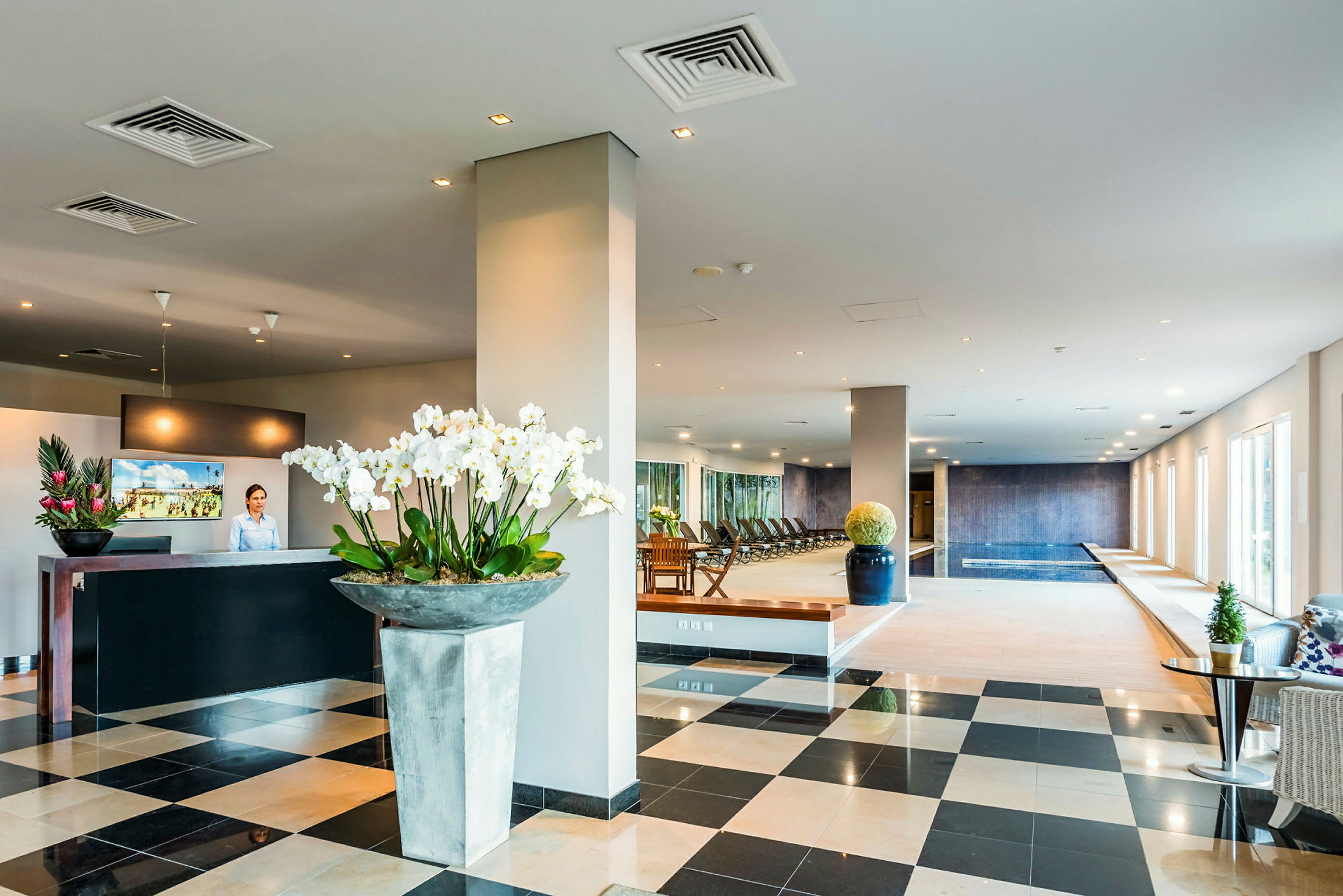 Ett hotellområde med reception och spaavdelning, inklusive pool och sittgrupper. (AI-genererad text)