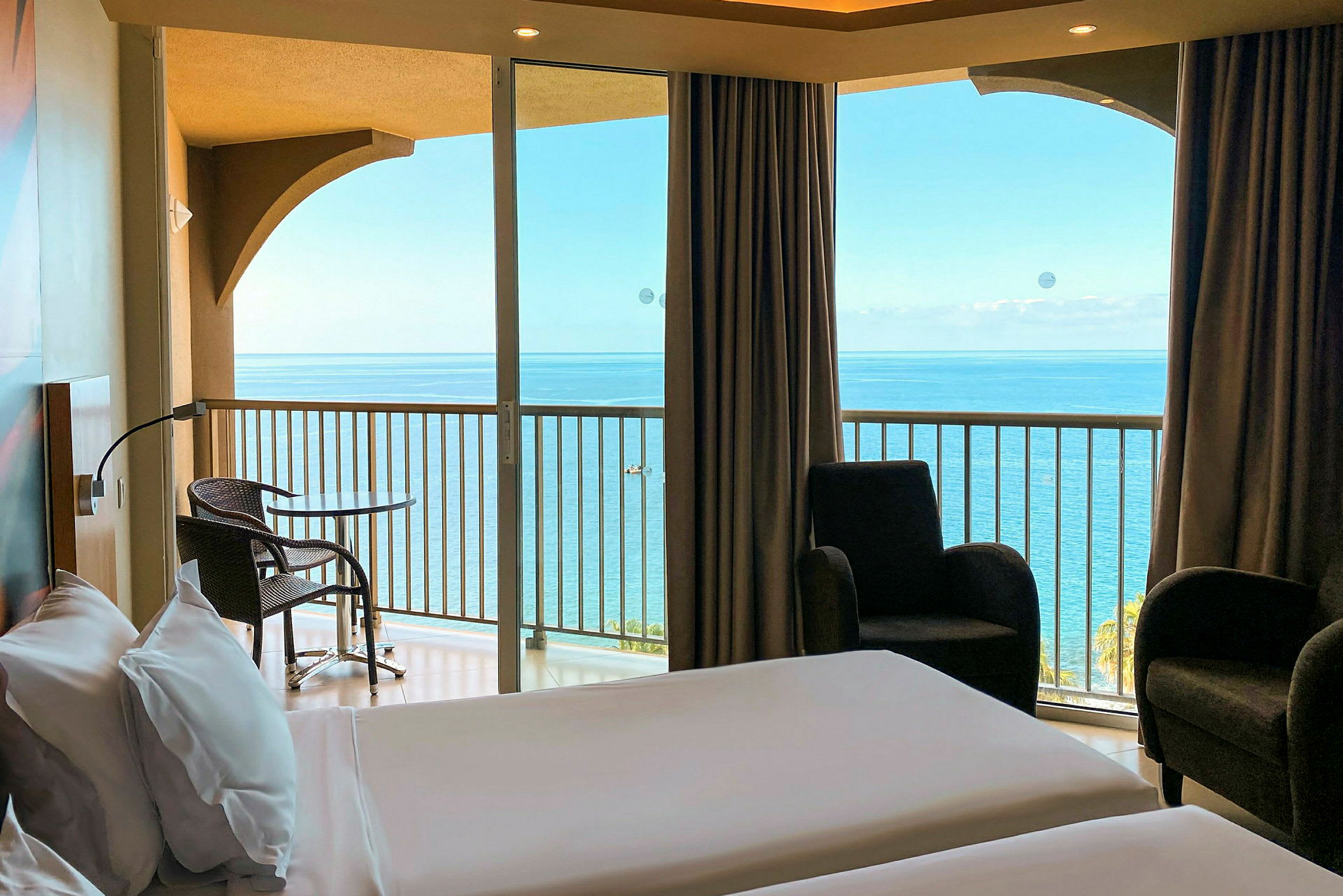 Hotellrum med utsikt över havet från balkongen. (AI-genererad text)
