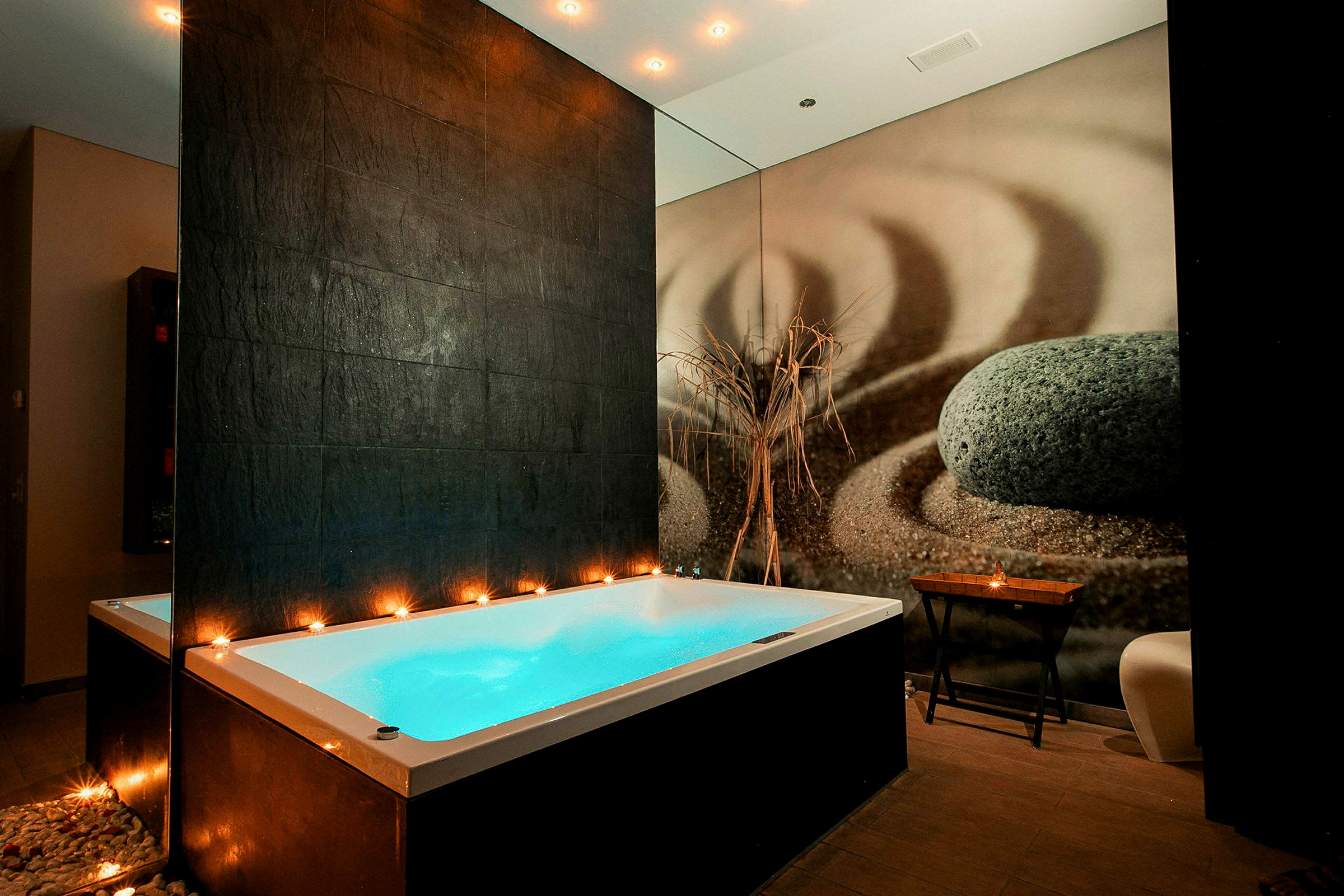 En modern spa-miljö med ett upplyst bubbelbad och dekorativa element. (AI-genererad text)