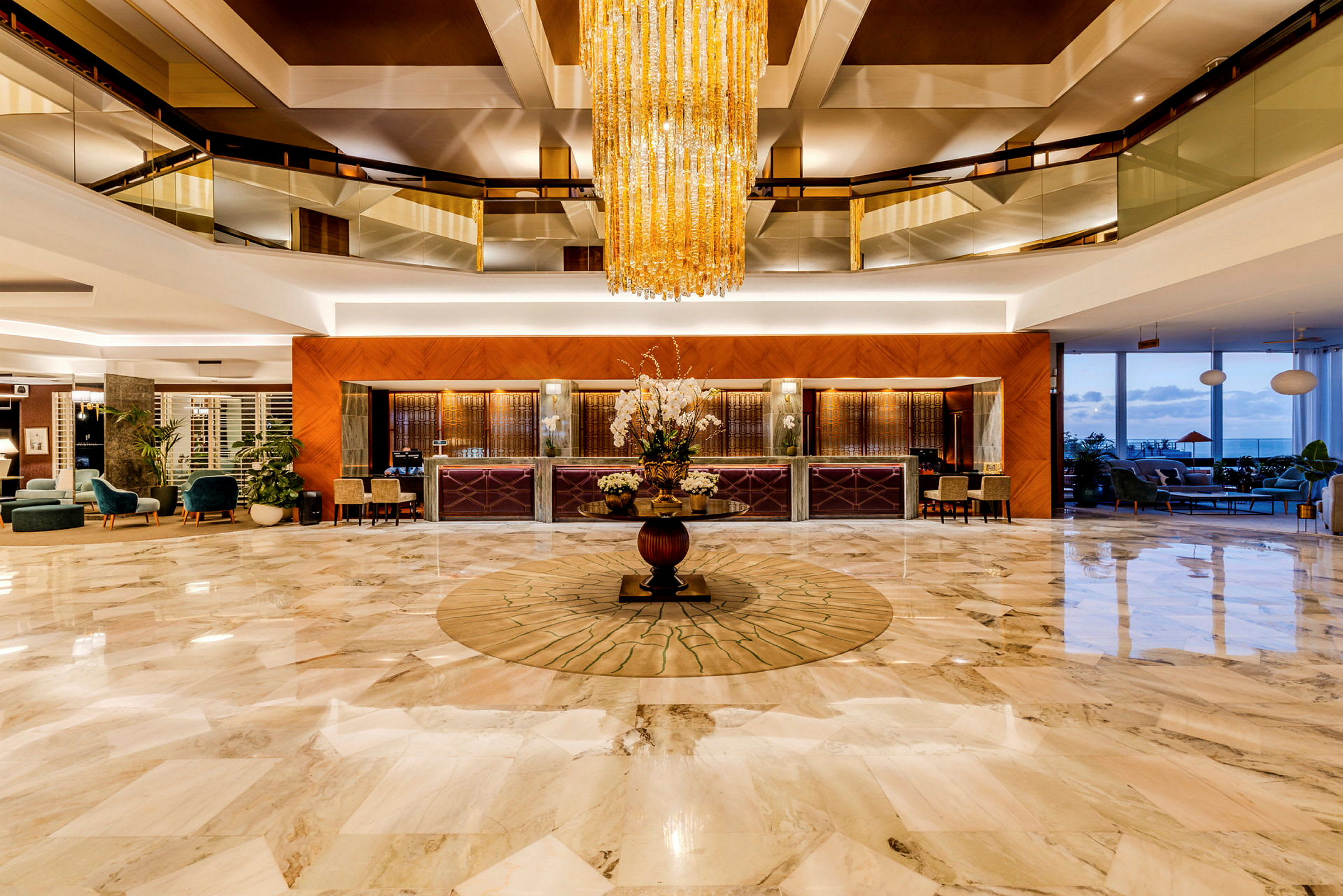 En elegant hotellobby med marmorgolv, en stor kristallkrona och ett receptionsområde. (AI-genererad text)