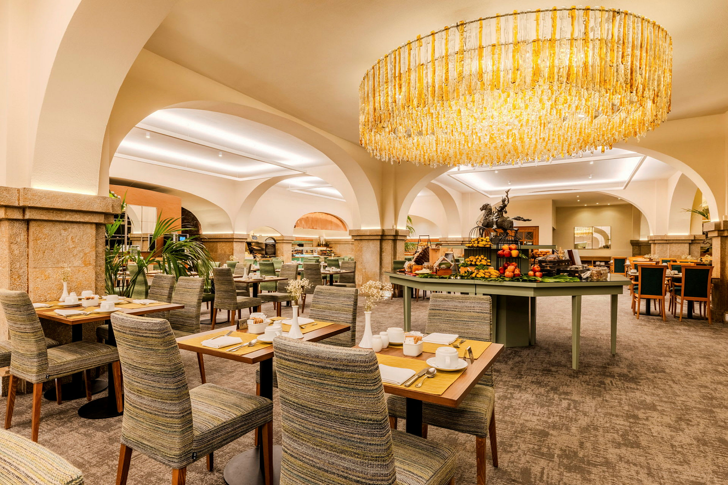 Interiör av en elegant restaurang med sittplatser och en ljuskrona. (AI-genererad text)