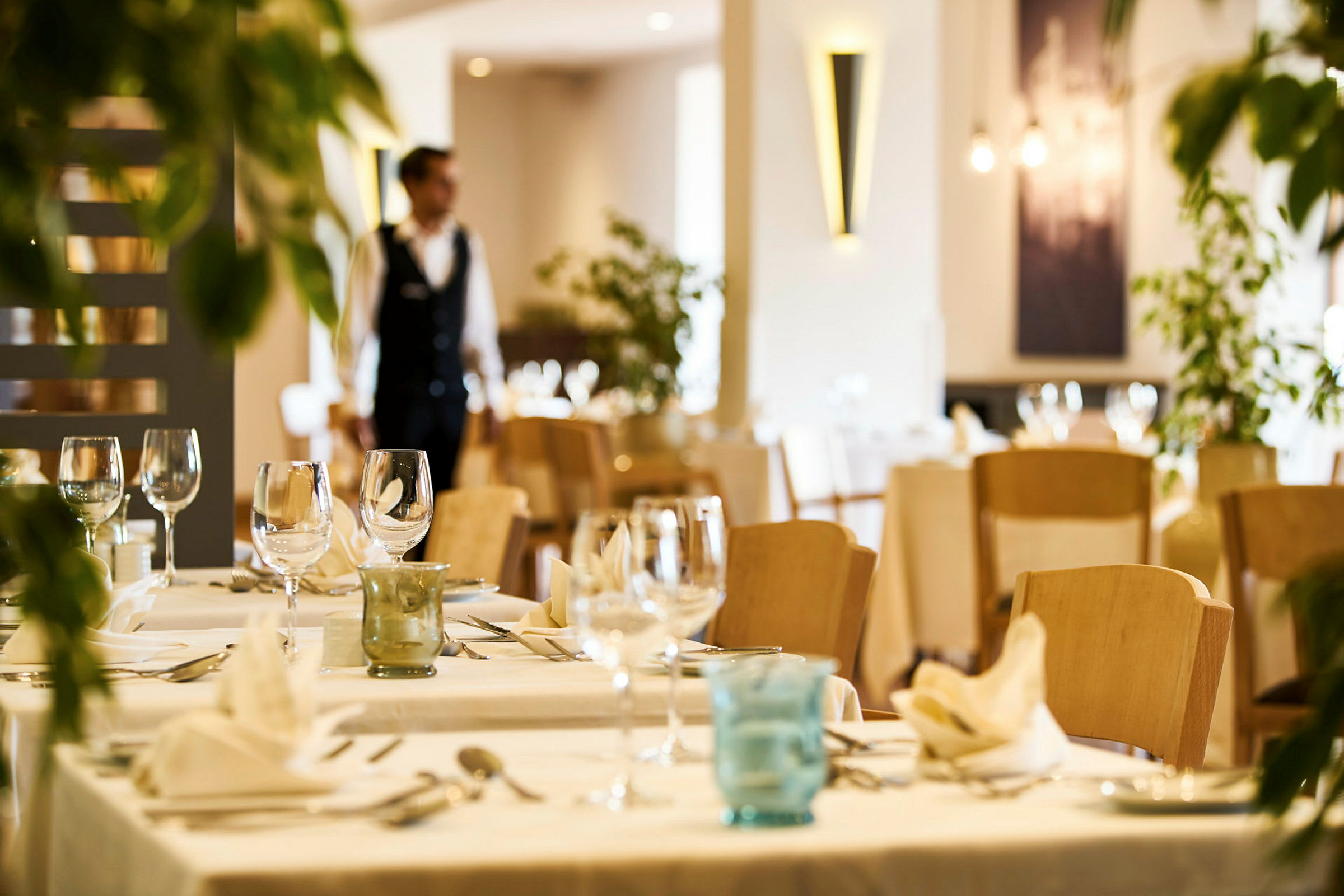 Restaurangmiljö med dukade bord och glas. (AI-genererad text)