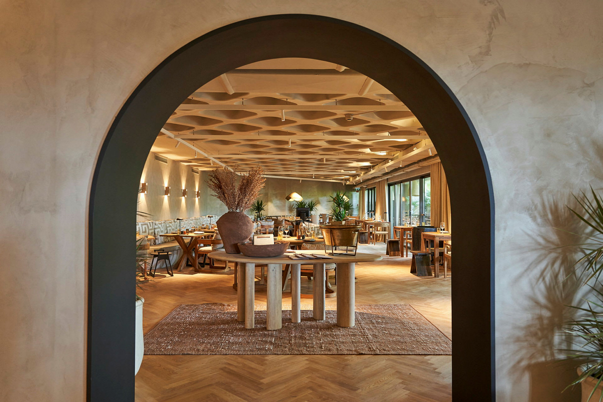 Arkitektur i en restaurang med en båge som öppning och trädetaljer i inredningen. (AI-genererad text)