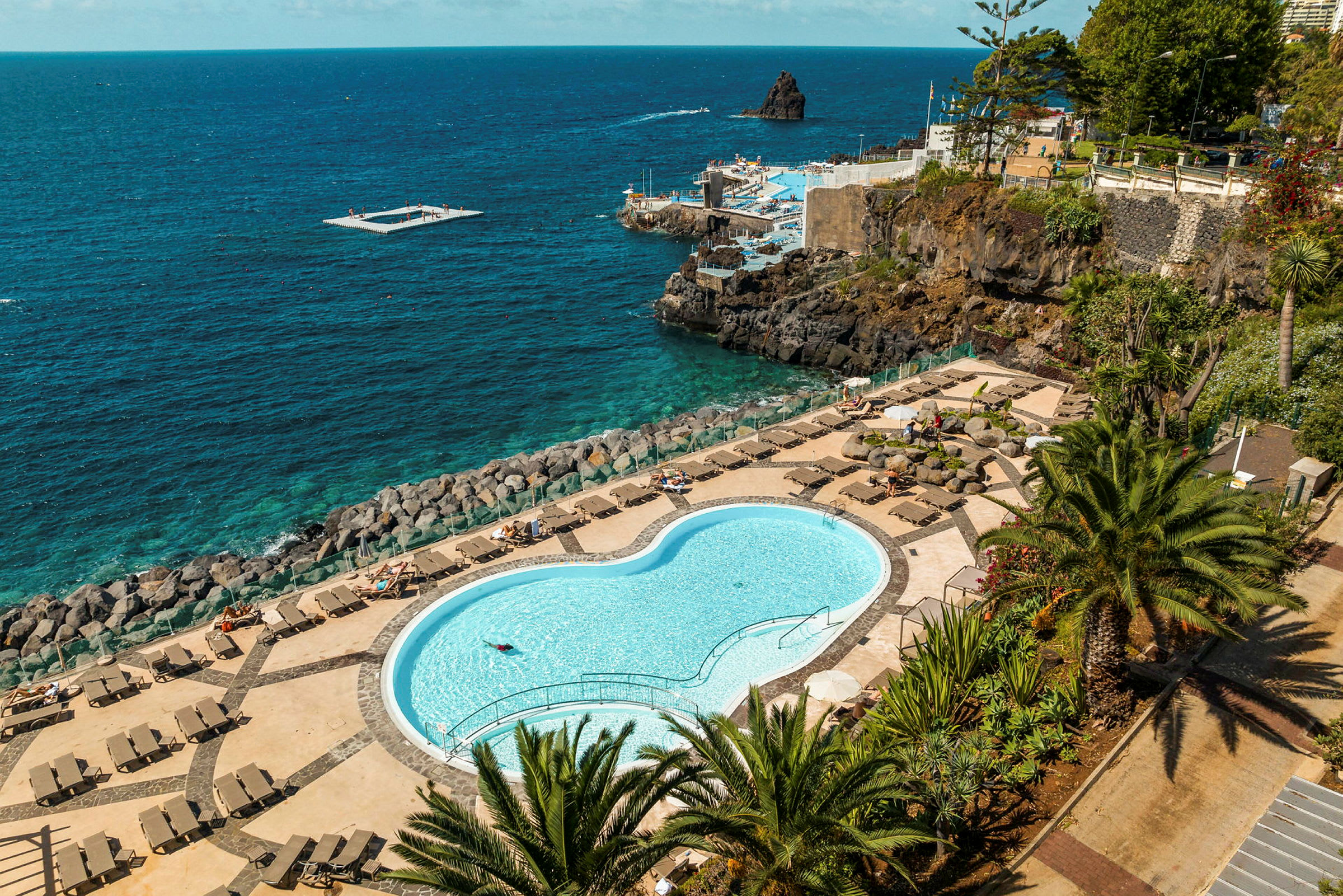 Sluten pool med vilstolar och utsikt över havet. (AI-genererad text)