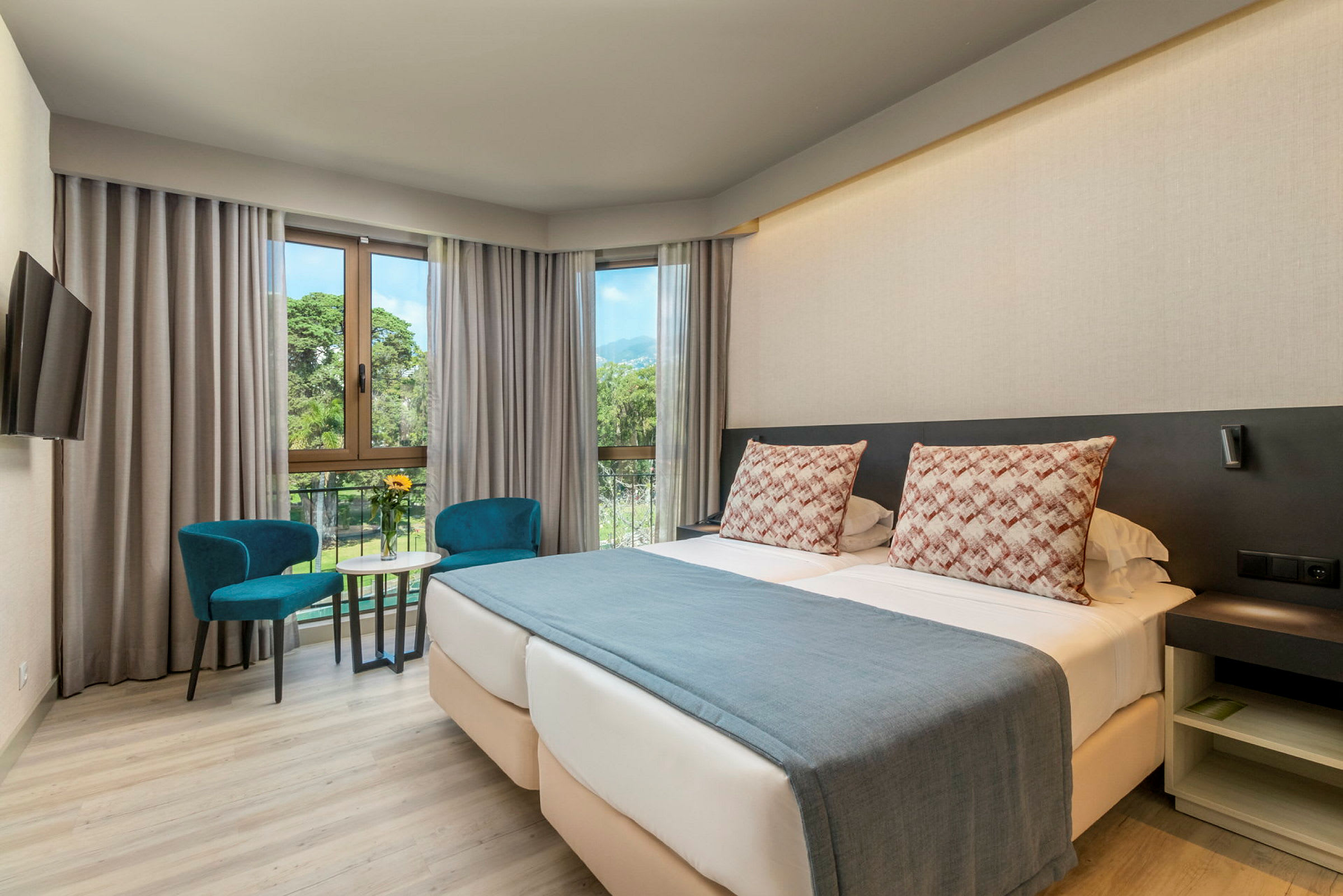 Ett hotellrum med en dubbelsäng, en sittgrupp och stora fönster. (AI-genererad text)