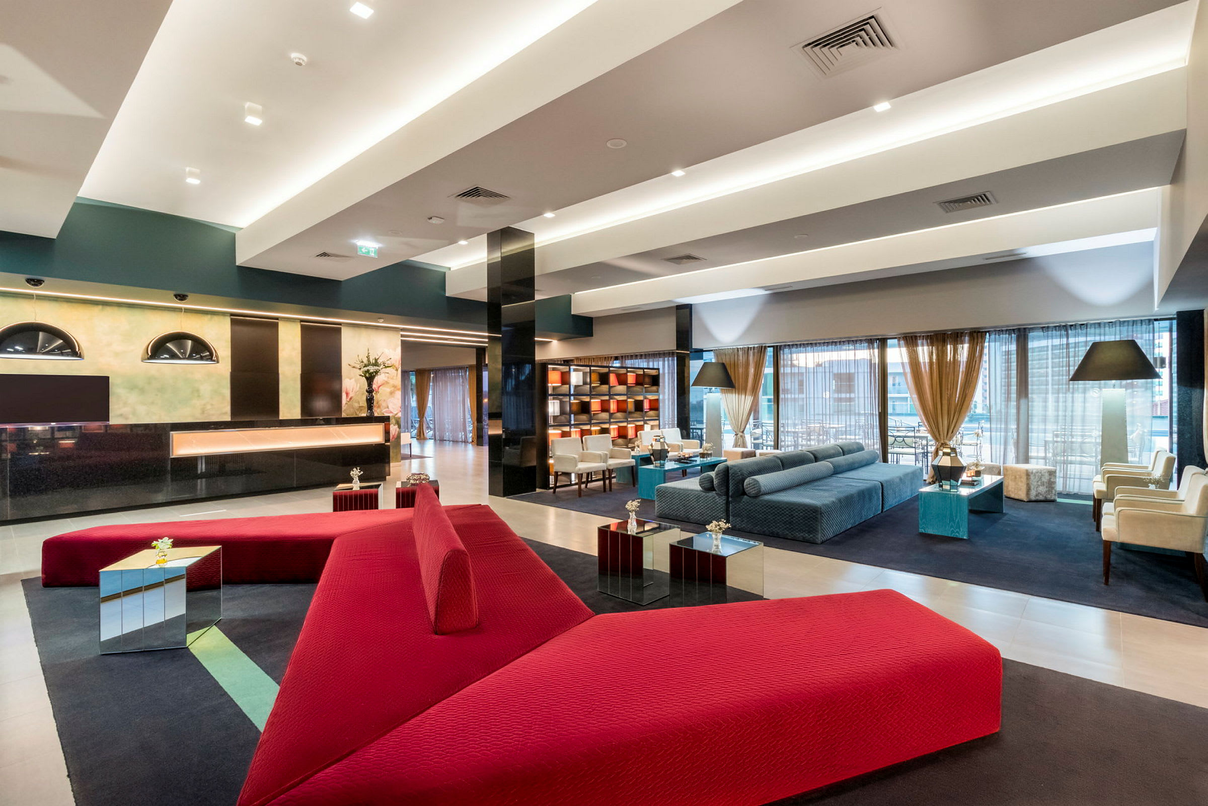 Modern hotellobby med röda och blå möbler. (AI-genererad text)