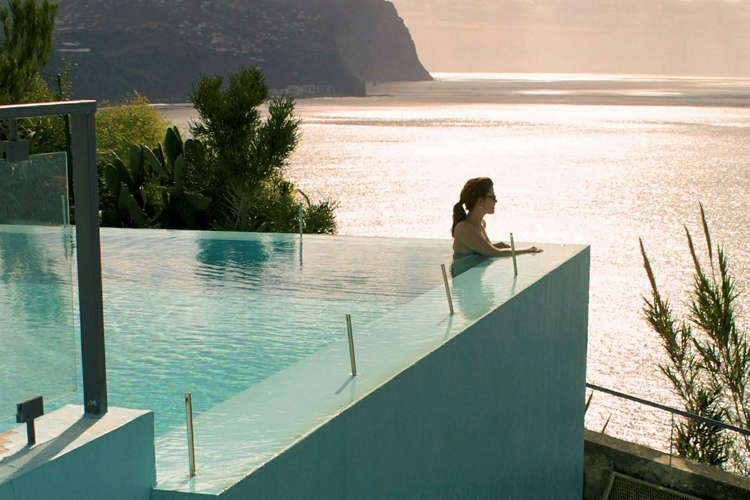 Infinity-pool med utsikt mot havet och kustlandskap. (AI-genererad text)