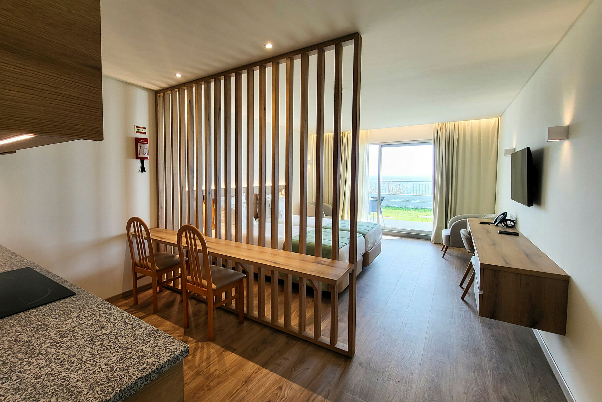 En välbelyst hotellrumsinteriör med avgränsning av trälameller. (AI-genererad text)