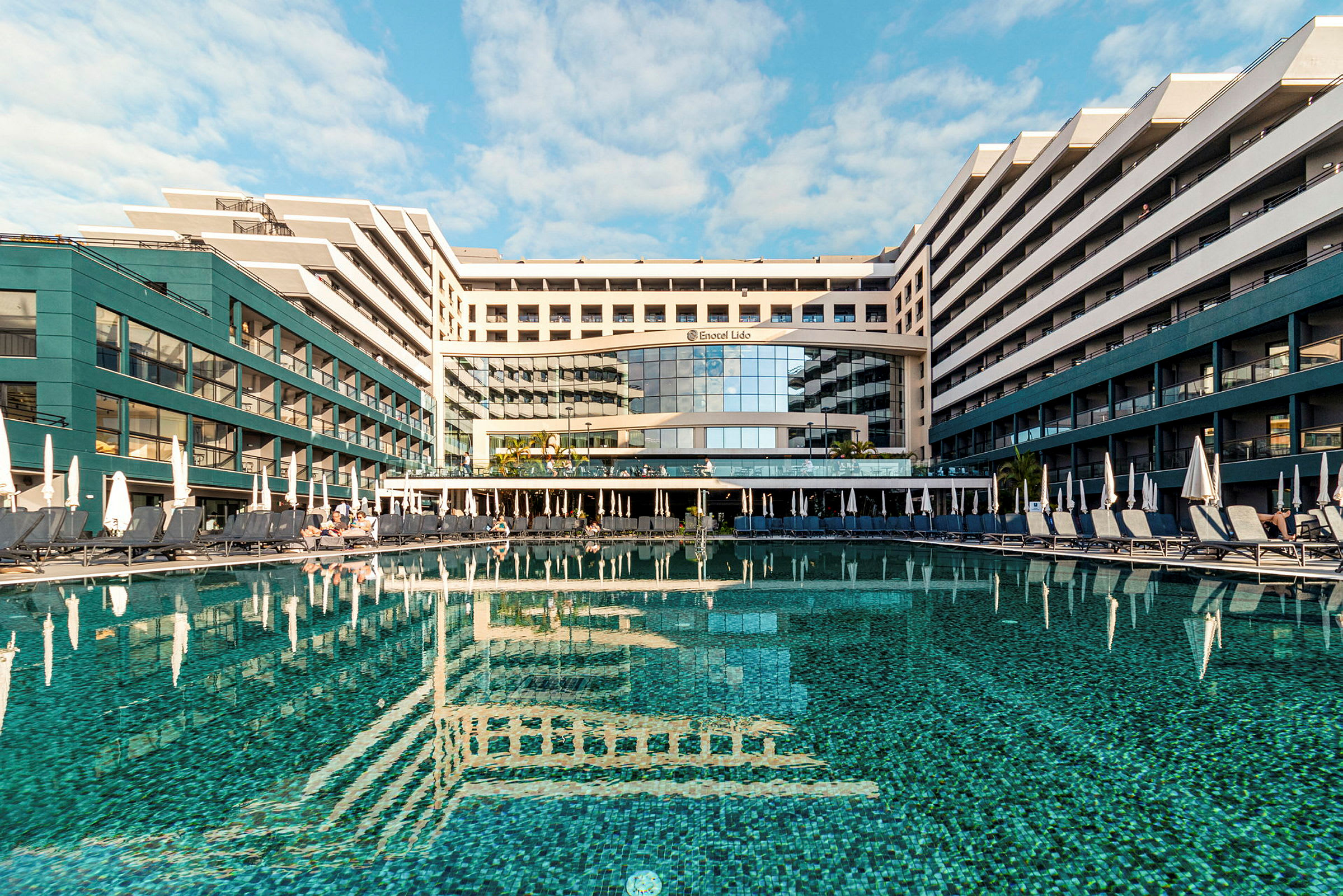 Hotell med pool och solstolar utomhus. (AI-genererad text)