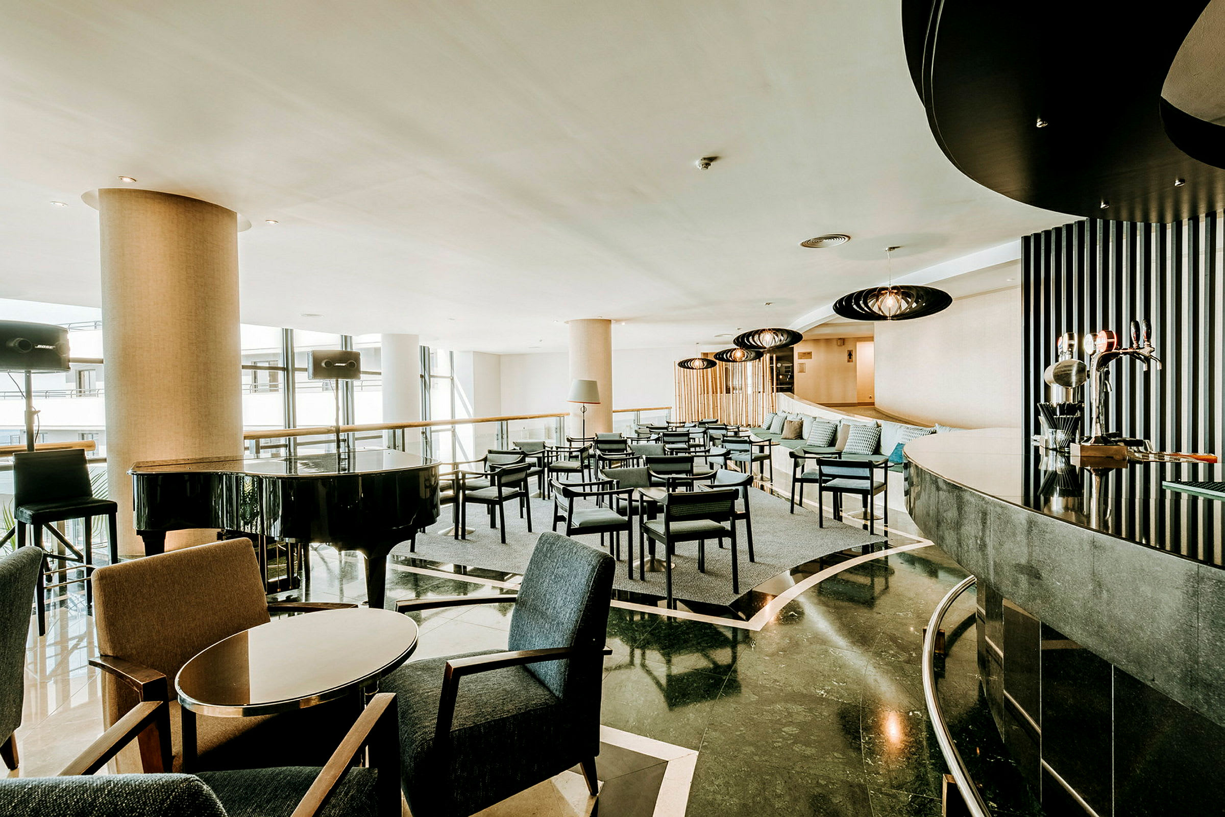 En modern hotellobby med sittgrupper och en svart flygel. (AI-genererad text)
