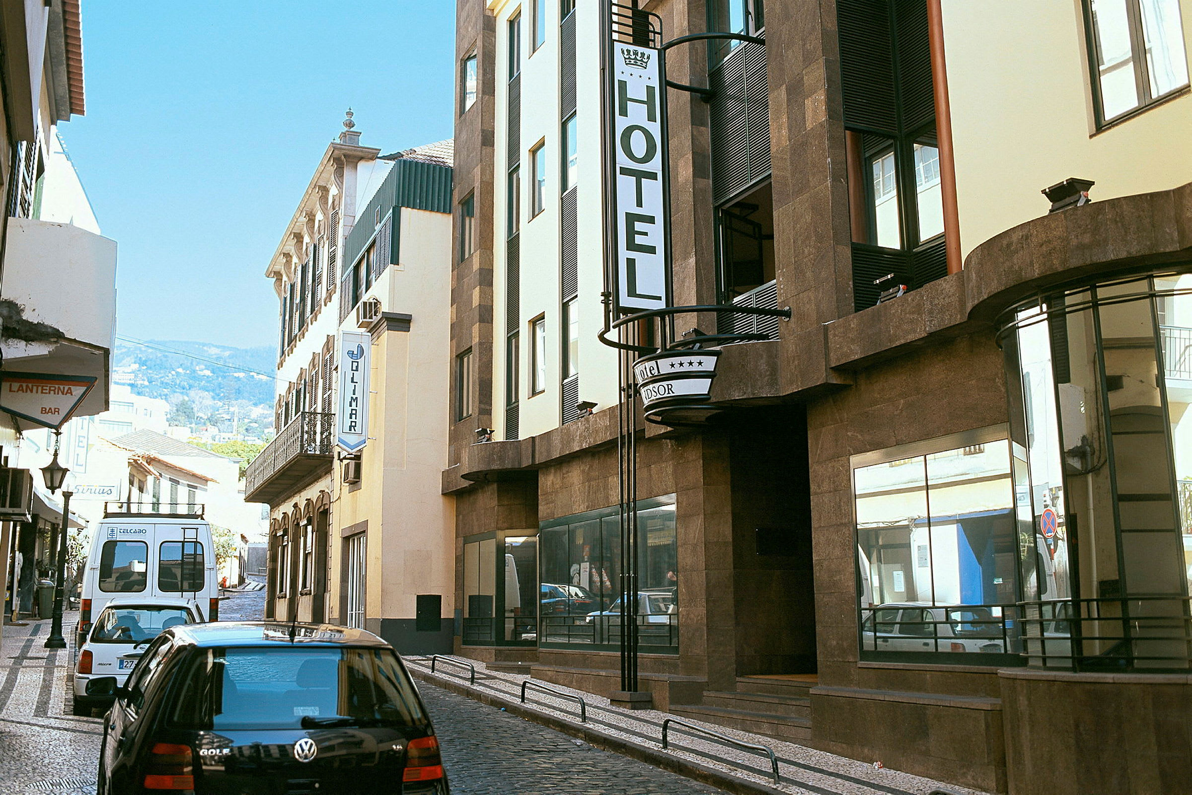 En gata med flera byggnader, där en skylt för ett hotell är tydligt synlig. (AI-genererad text)