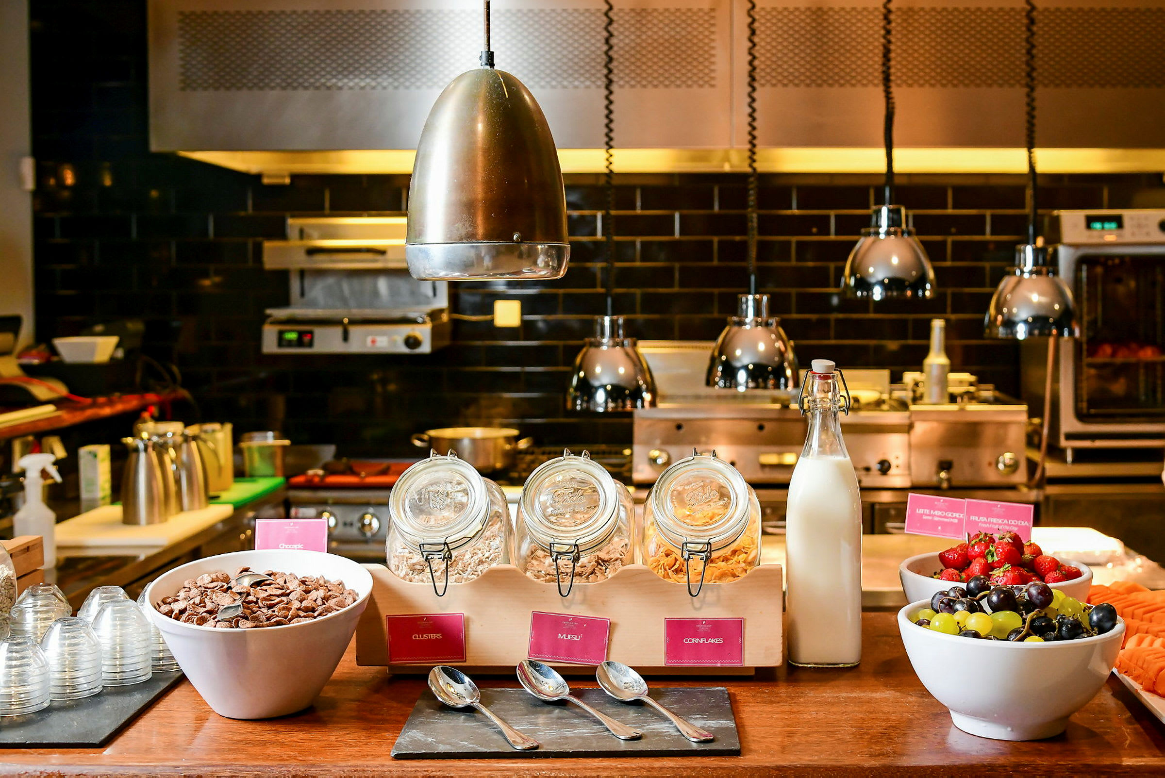 En frukostbuffé med flingor, mjölk och frukt serveras på ett bord. (AI-genererad text)