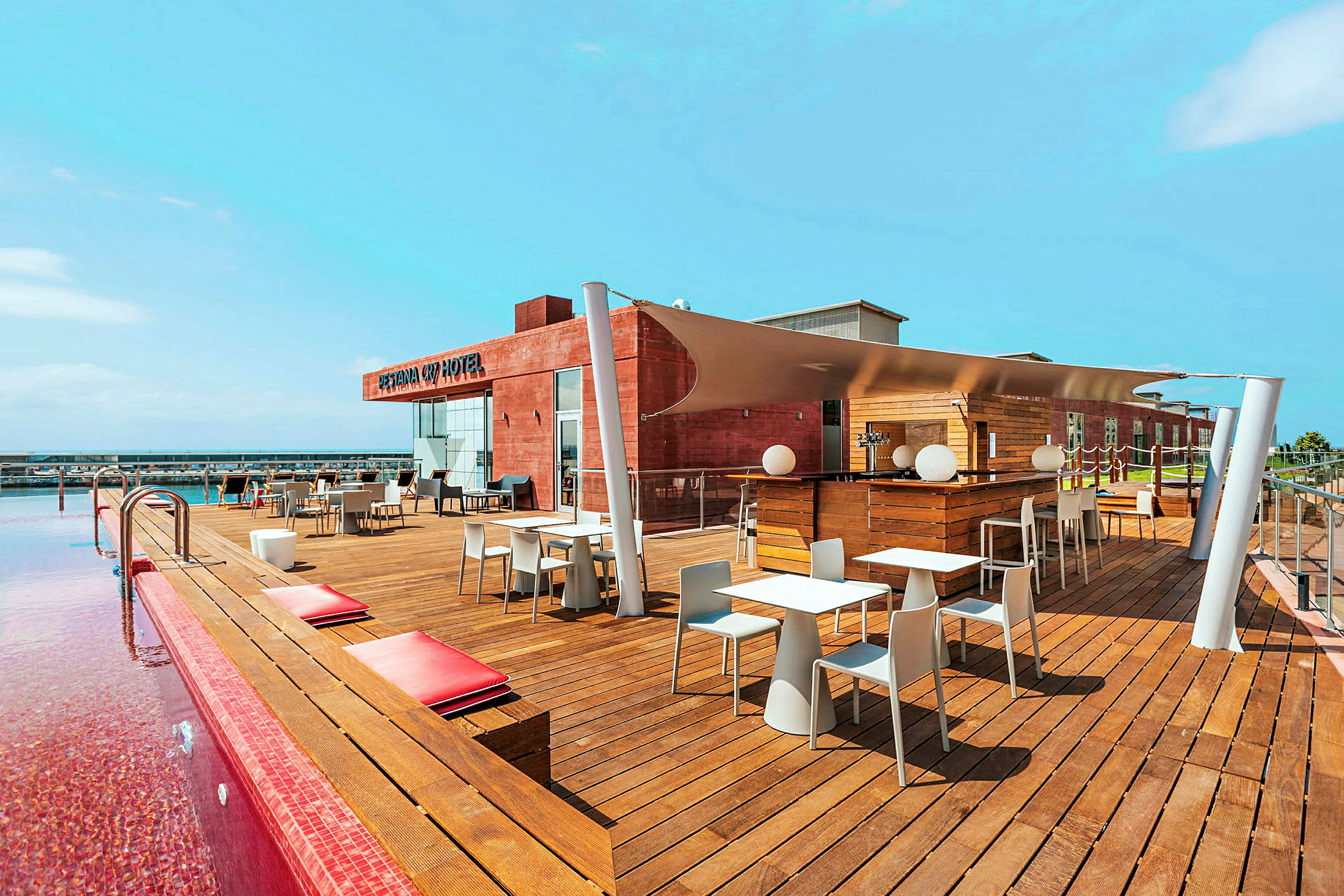 Takterrass med pool, sittplatser och bar vid ett hotell. (AI-genererad text)