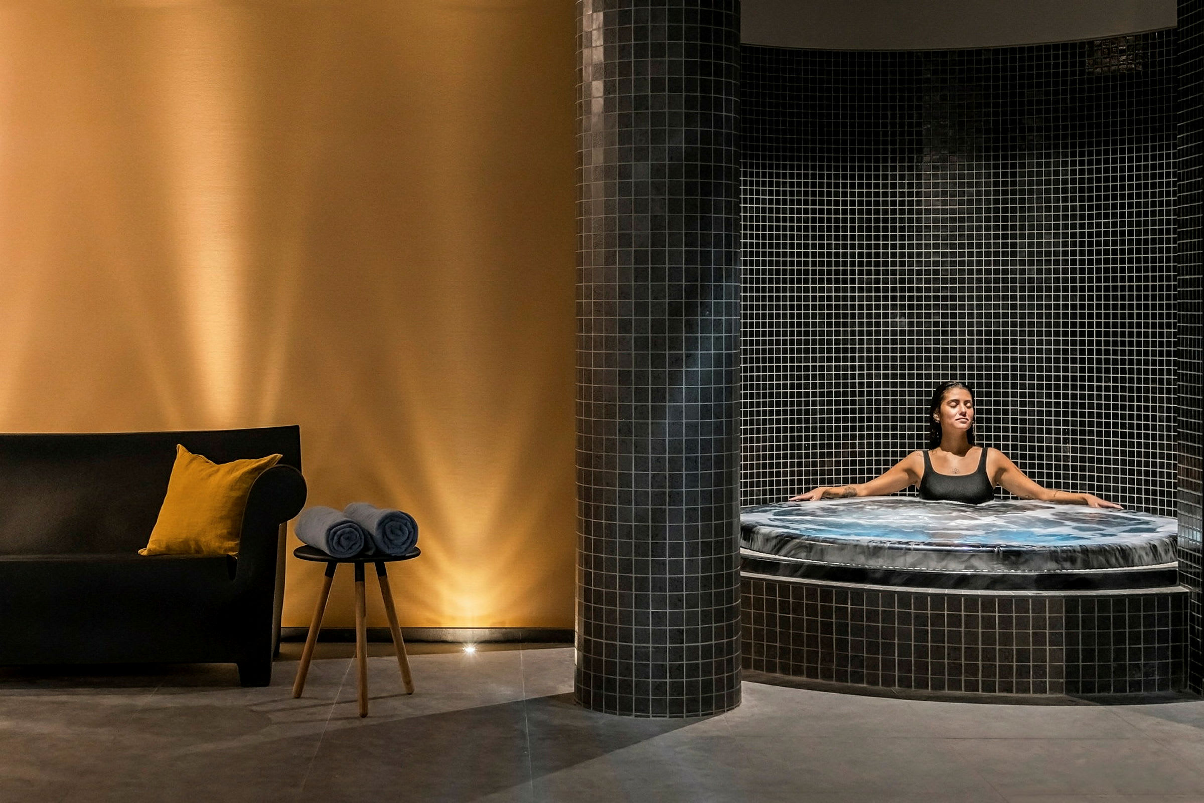 En avkopplande miljö med en jacuzzi och ett sittområde. (AI-genererad text)