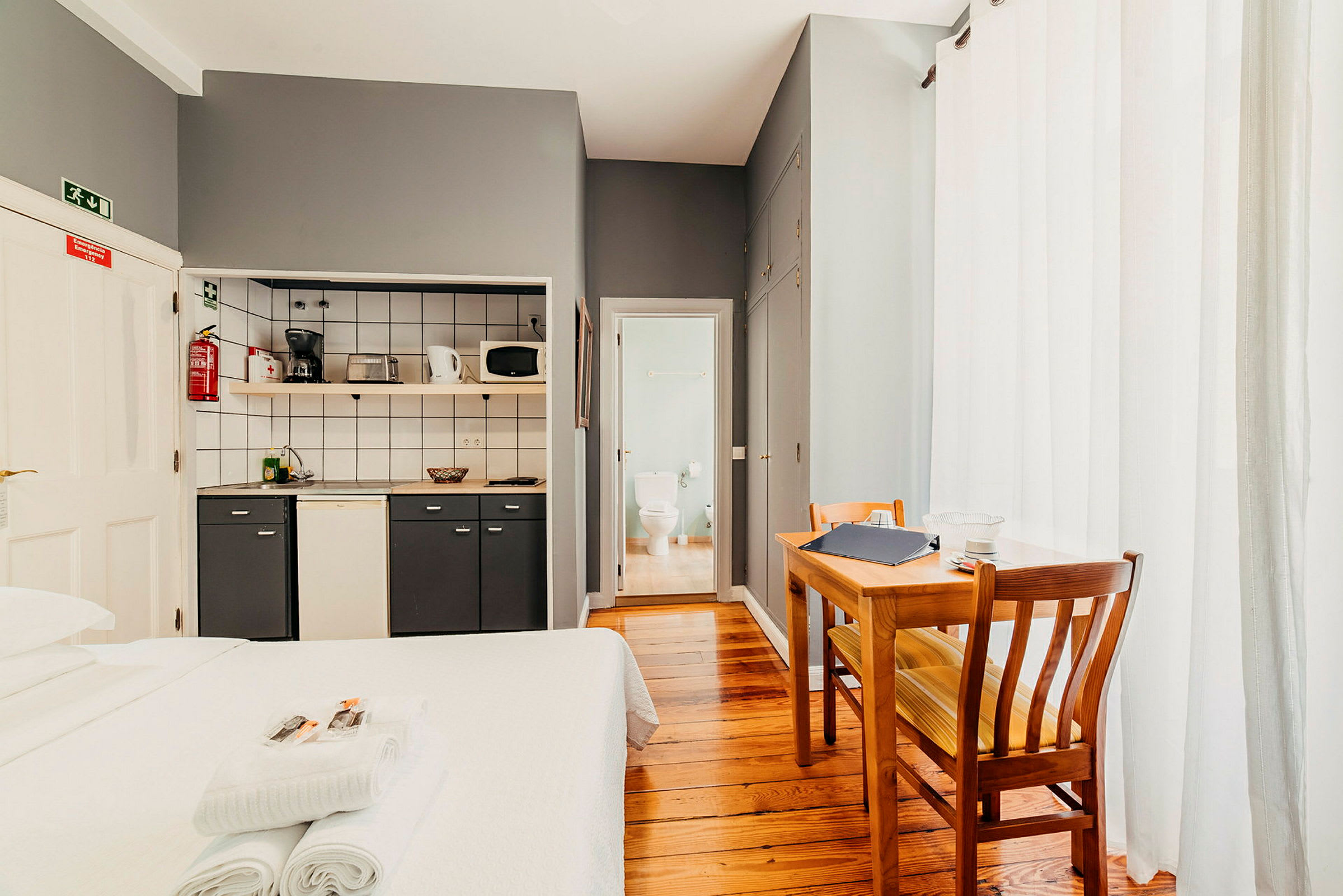 Ett hotellrum med köksdel, matbord och badrum. (AI-genererad text)