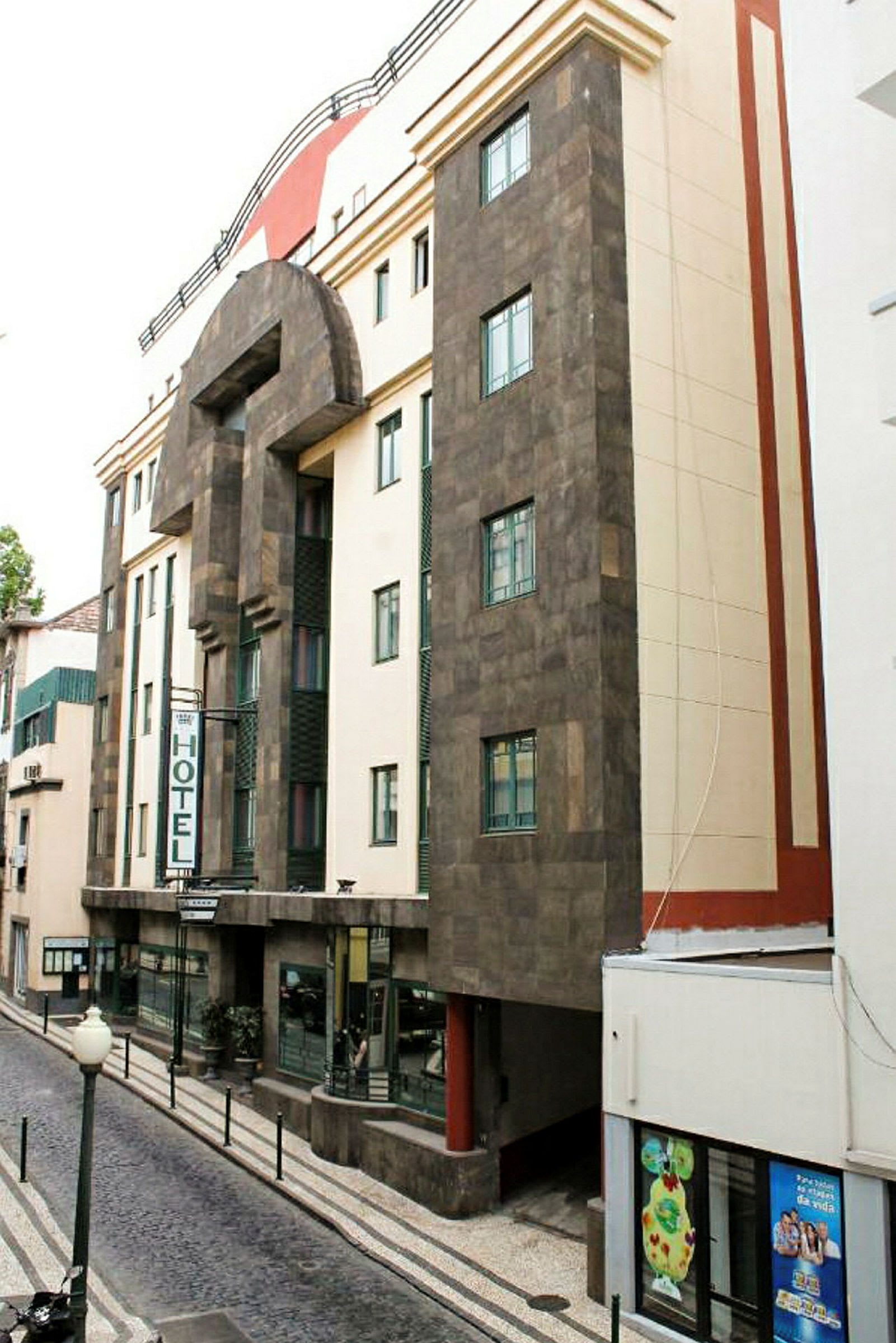 Hotellfasad i stadsmiljö med neonskylt och detaljrik arkitektur. (AI-genererad text)
