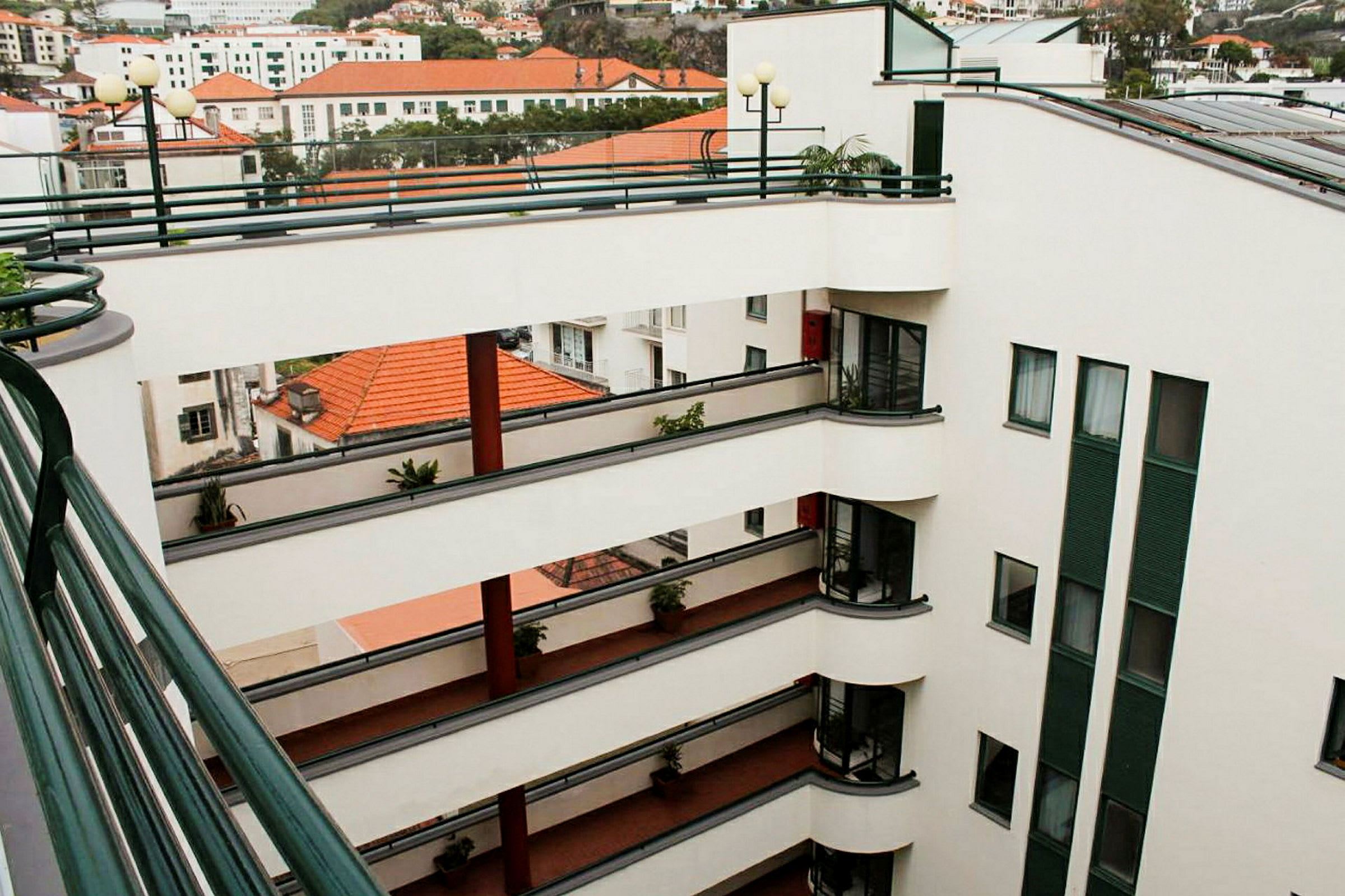 En modern byggnad med flera öppna våningsplan och balkonger som vetter mot en innergård. (AI-genererad text)