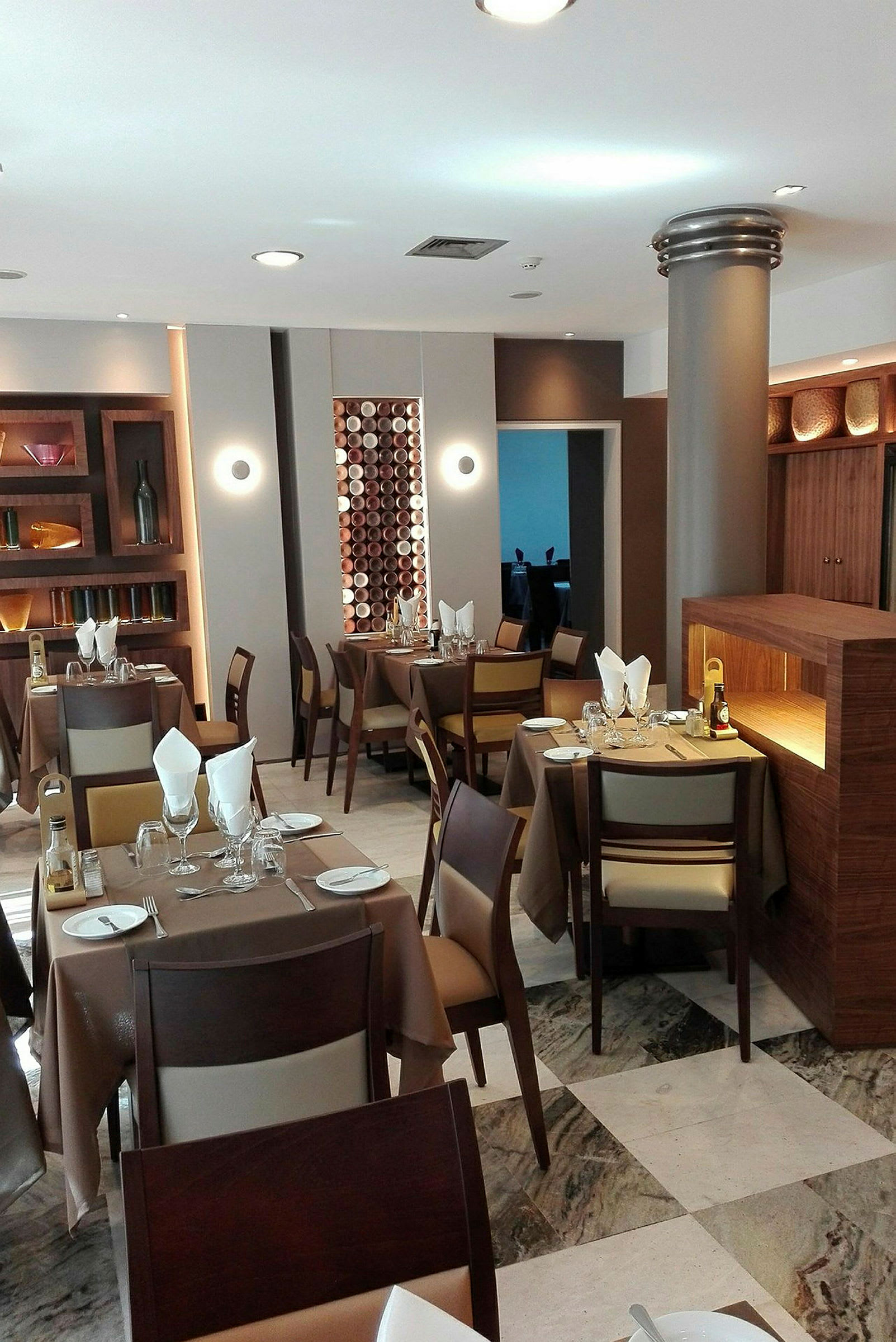 En restauranginteriör med dukade bord och stolar, omgiven av modern träinredning. (AI-genererad text)