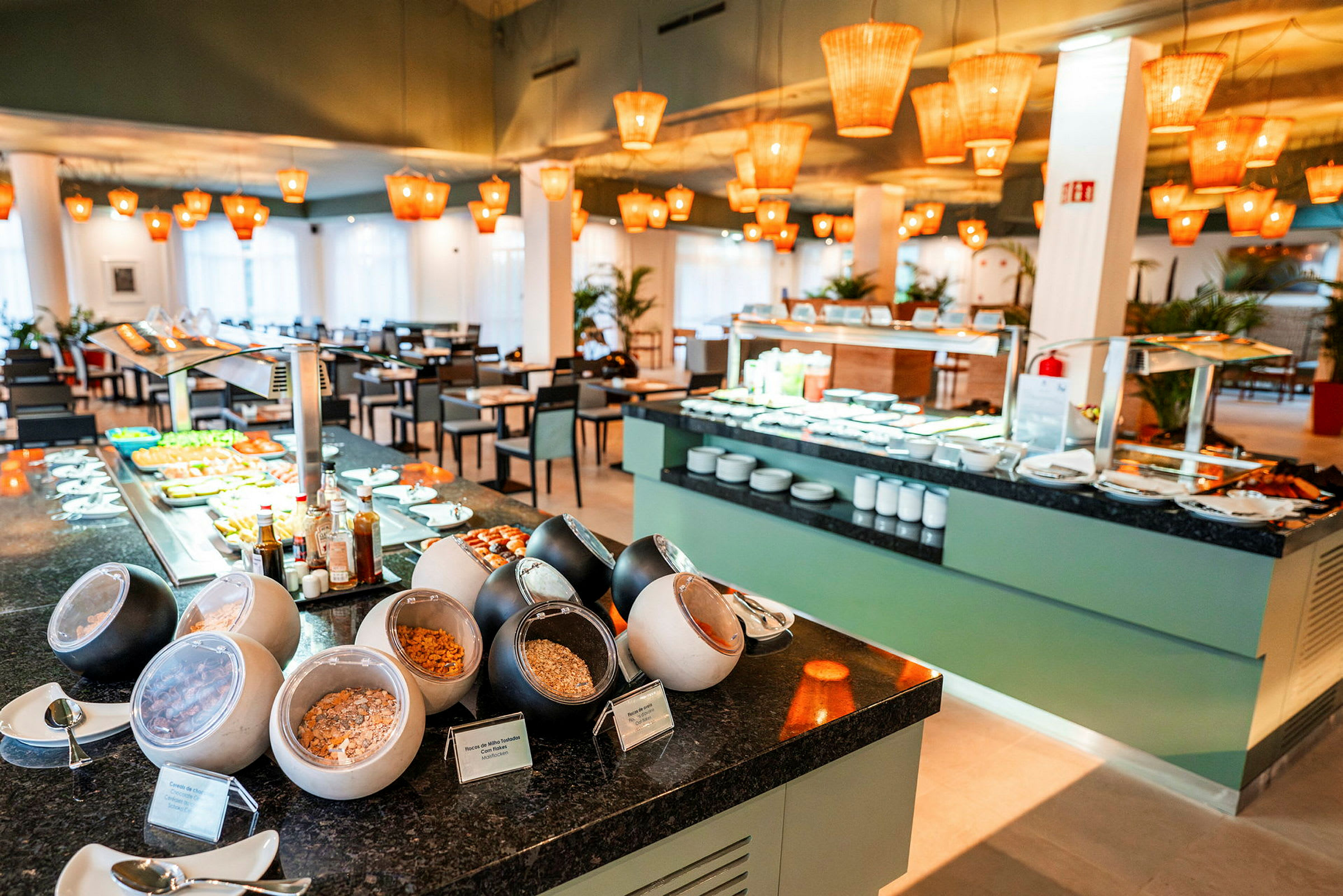 Frukostbuffé med olika stationer och sittplatser i restaurangmiljö. (AI-genererad text)