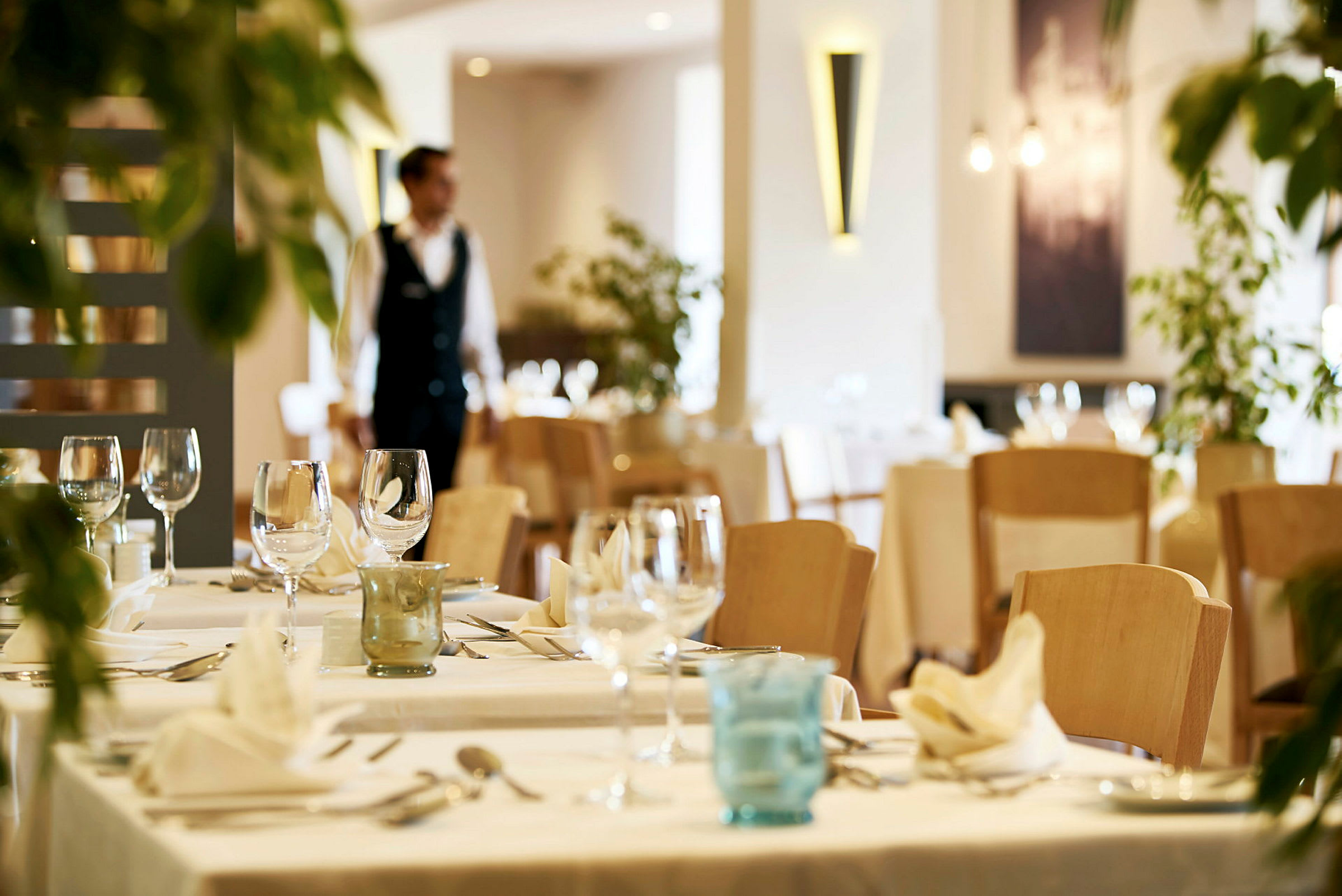 En restaurang med dukade bord och glas. (AI-genererad text)