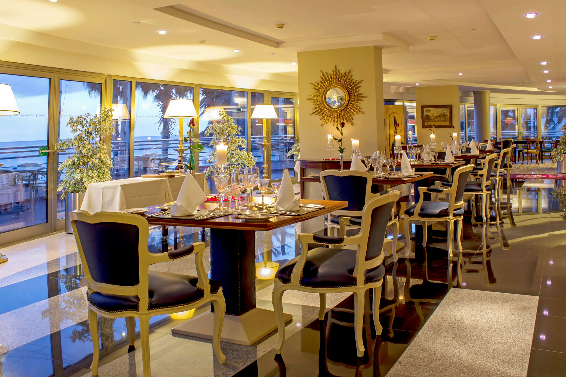 En elegant inredd restaurang med dukade bord och stora glasfönster som vetter mot en utsikt. (AI-genererad text)