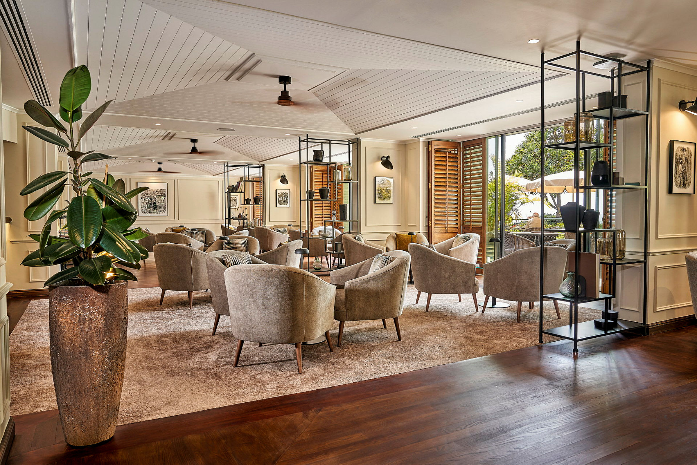 En modern och välmöblerad lounge med flera sittområden och stora fönster som släpper in naturligt ljus. (AI-genererad text)