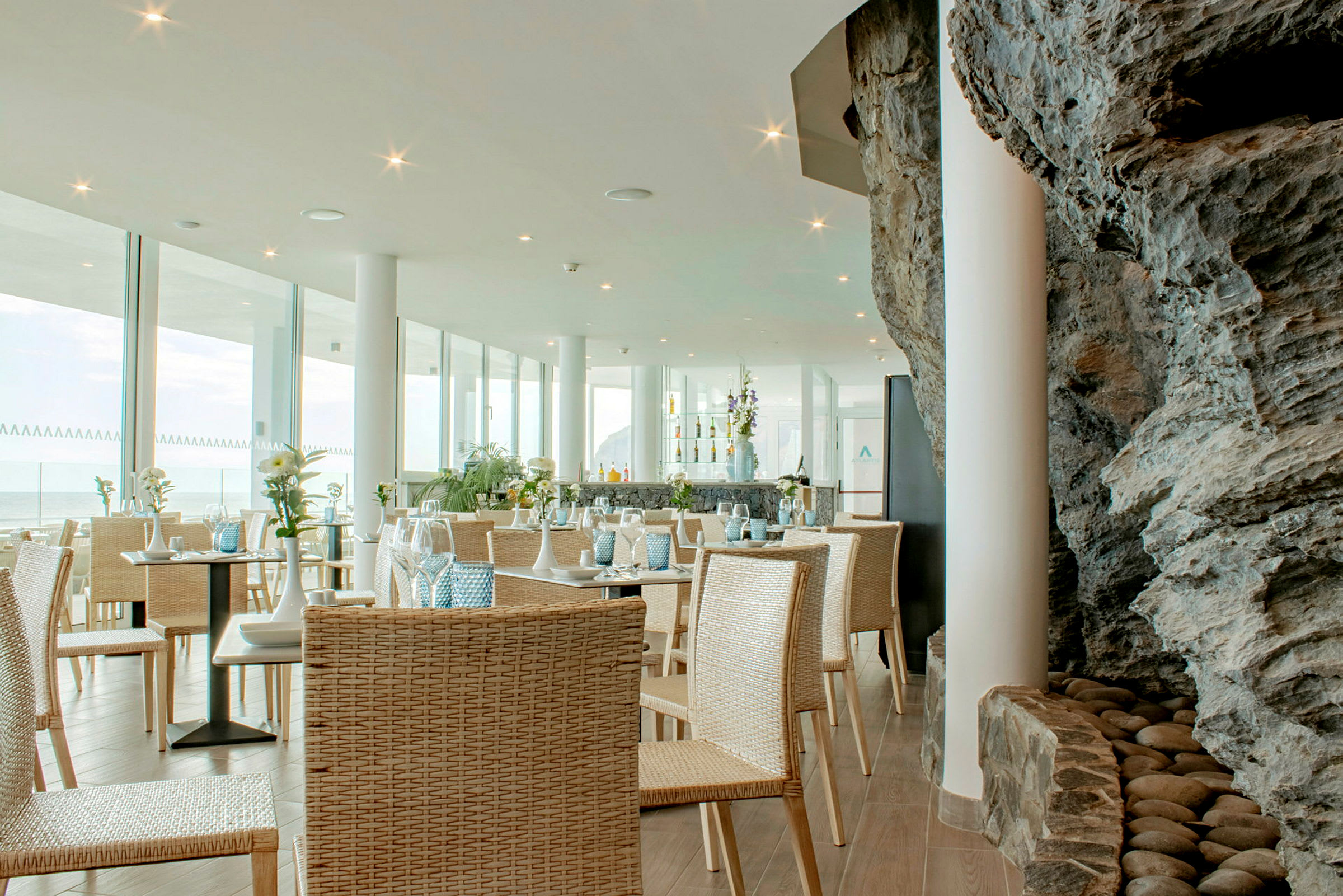 En restaurang med glasväggar och inredning i naturmaterial. (AI-genererad text)