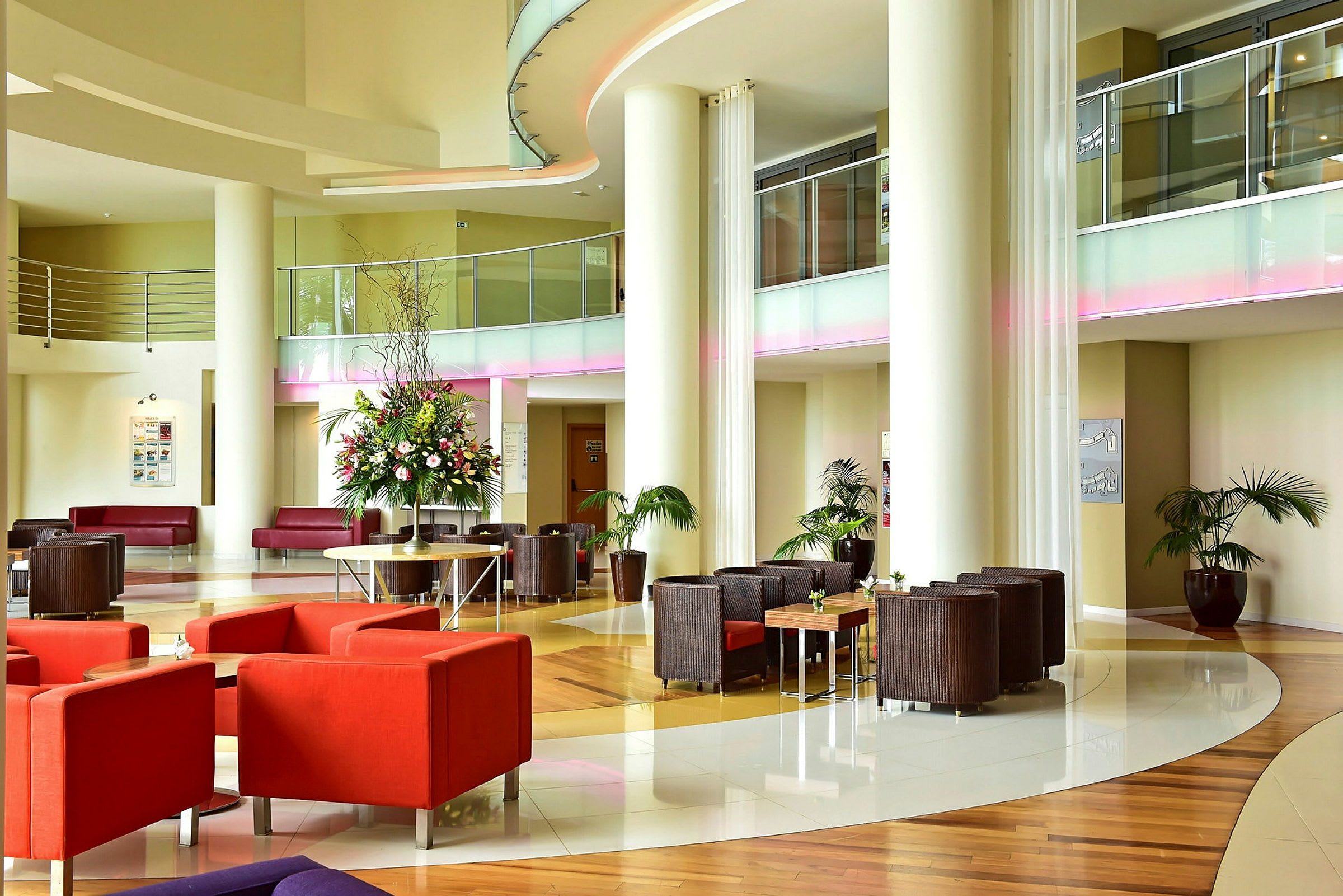 En modern hotellobby med runda möbler och en stor blomsterdekoration. (AI-genererad text)