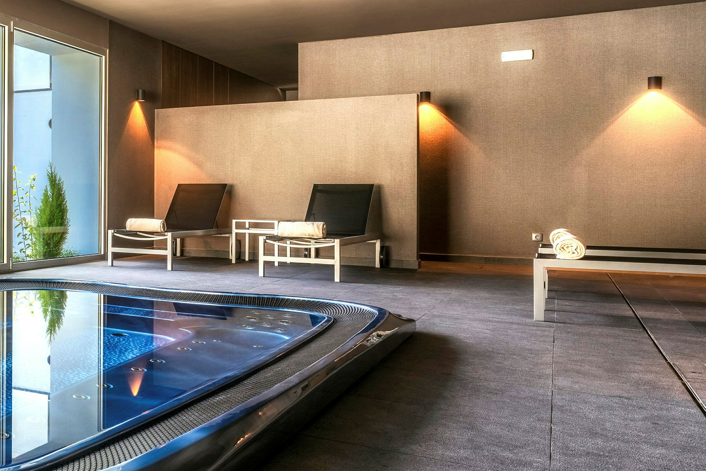 Bild av ett spaområde med sittplatser och en badpool. (AI-genererad text)