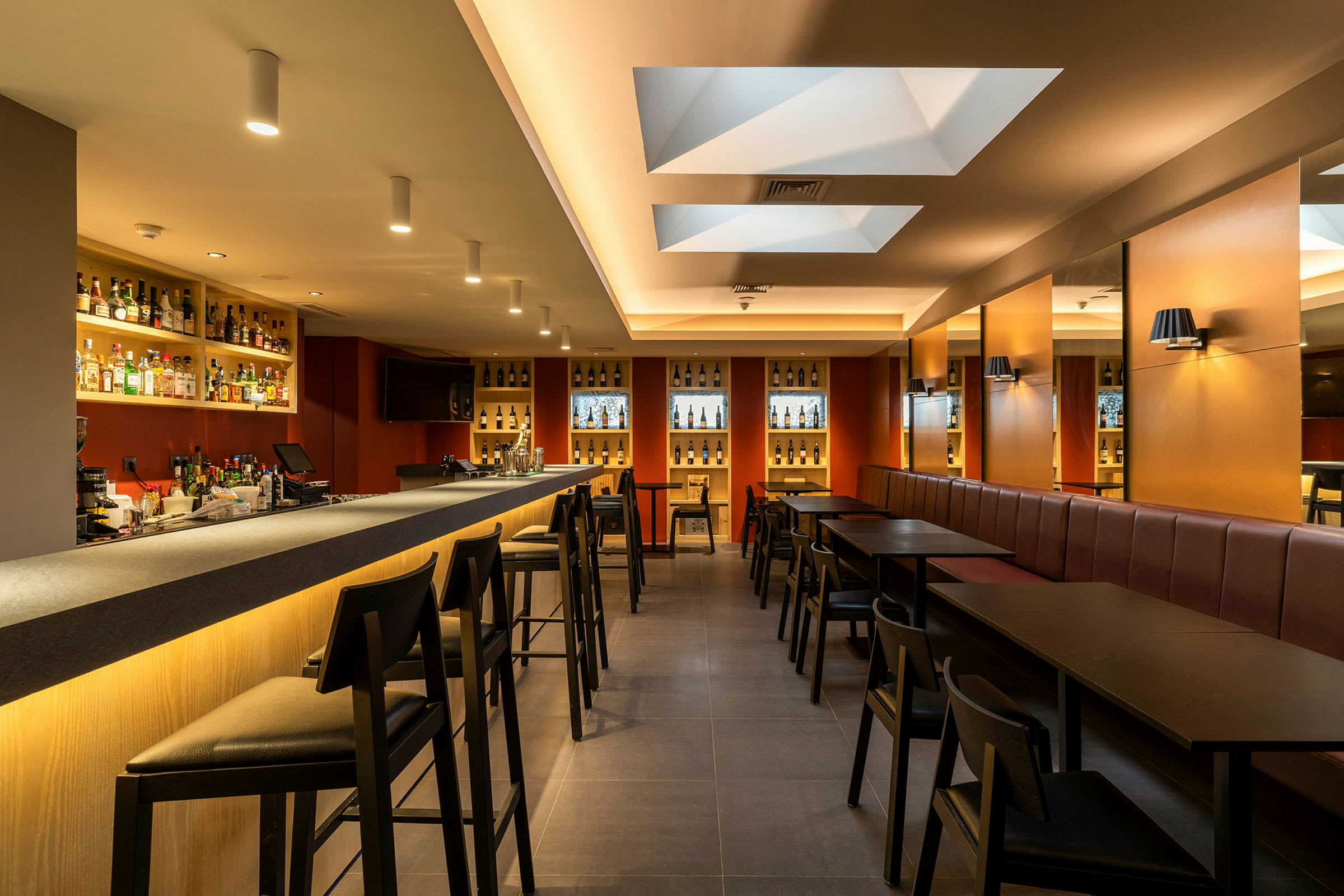 Interiör av en modern bar med bardisk, stolar och bord. (AI-genererad text)