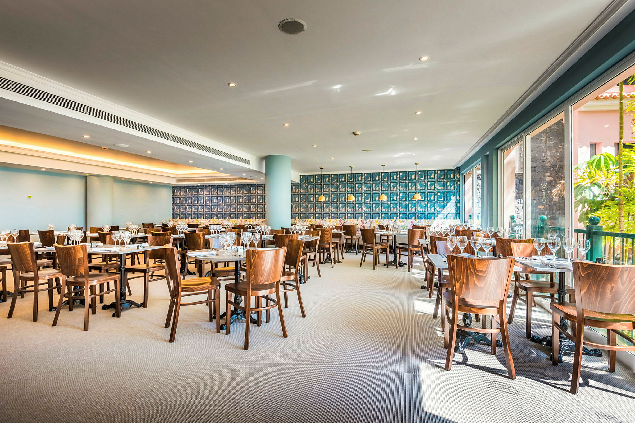 En restaurang med bord och trästolar, dekorerad med flera vinglas. (AI-genererad text)