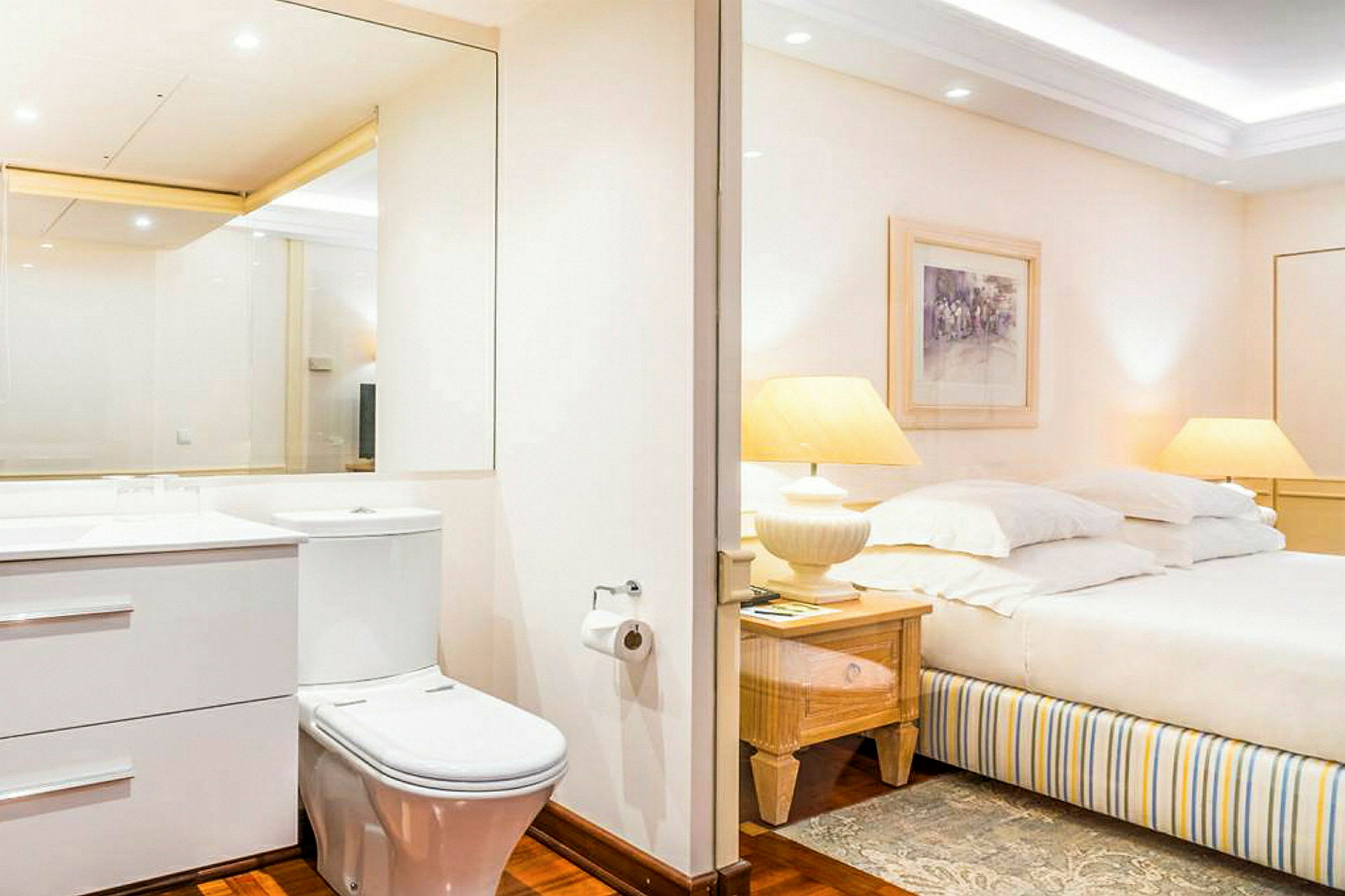Ett hotellrum med en toalett och ett sängområde. (AI-genererad text)