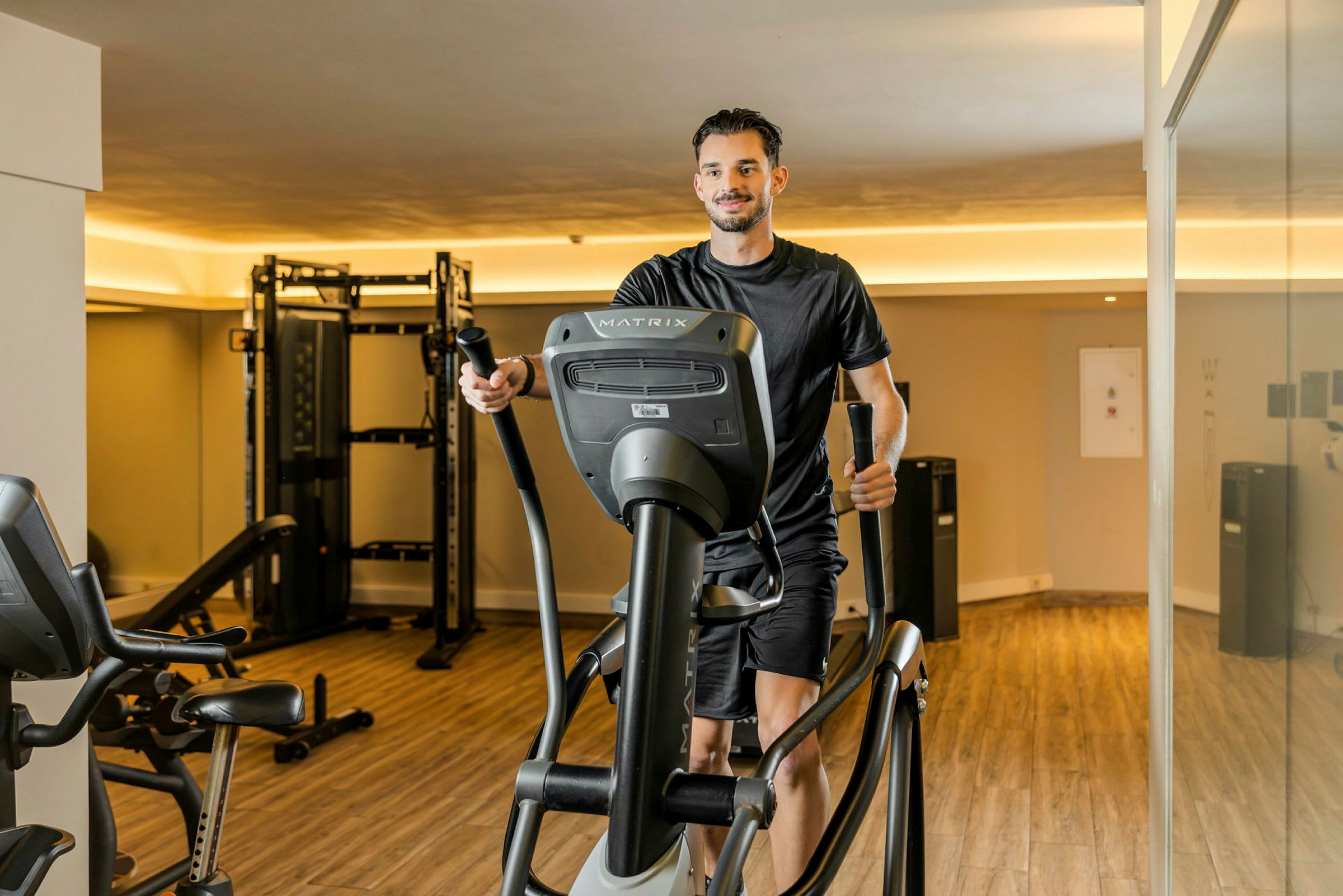 En person tränar på en crosstrainer i ett gym. (AI-genererad text)
