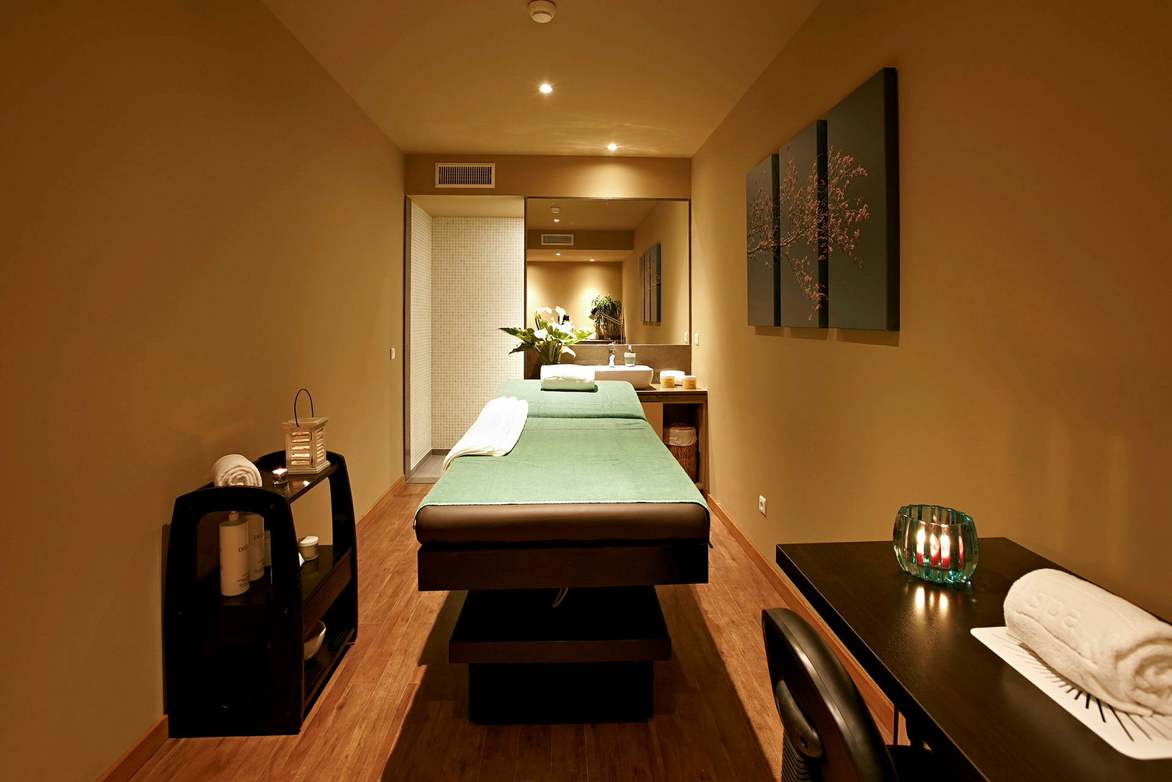 Ett spa-rum med en massagebänk, ljus och dekorationer. (AI-genererad text)