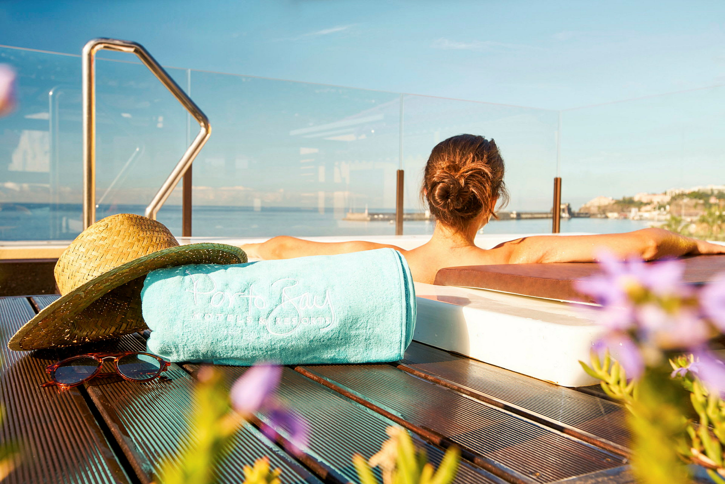 En person ligger avslappnad i en bubbelpool med utsikt över havet. (AI-genererad text)