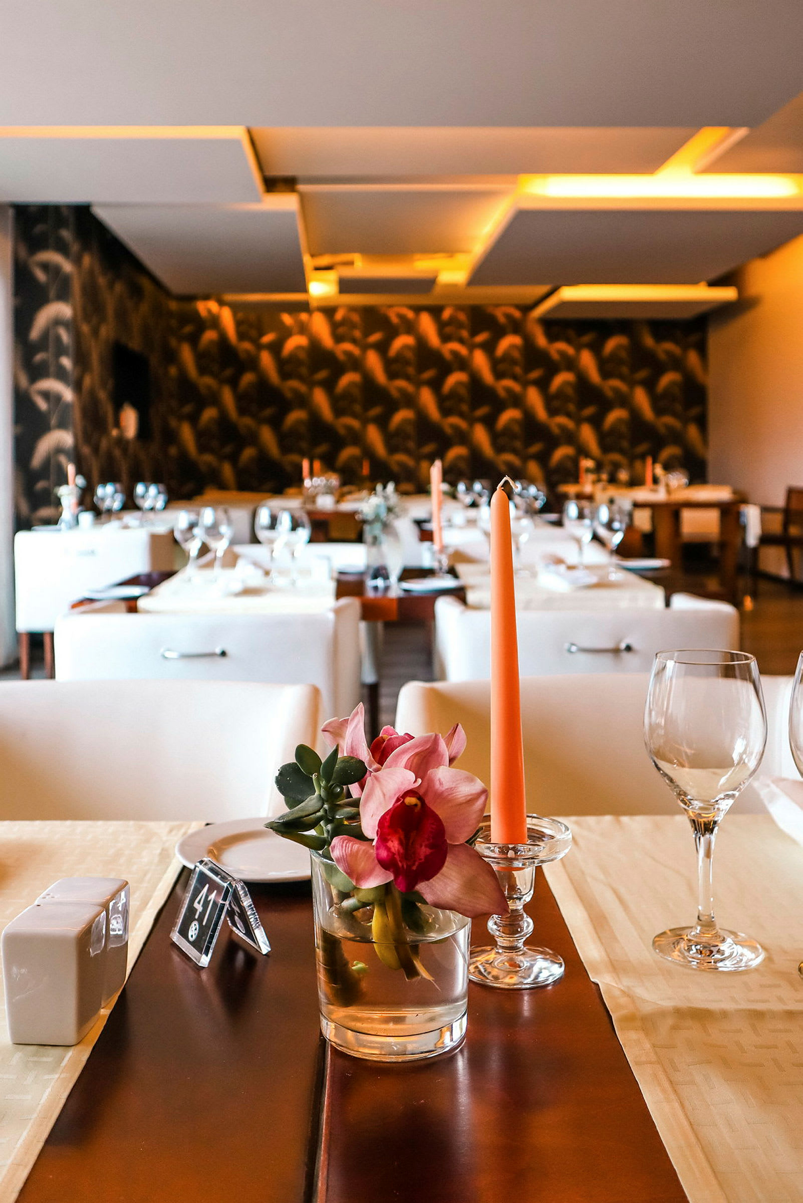 En elegant restaurang med dukade bord, dekorerade med blommor och ljus. (AI-genererad text)