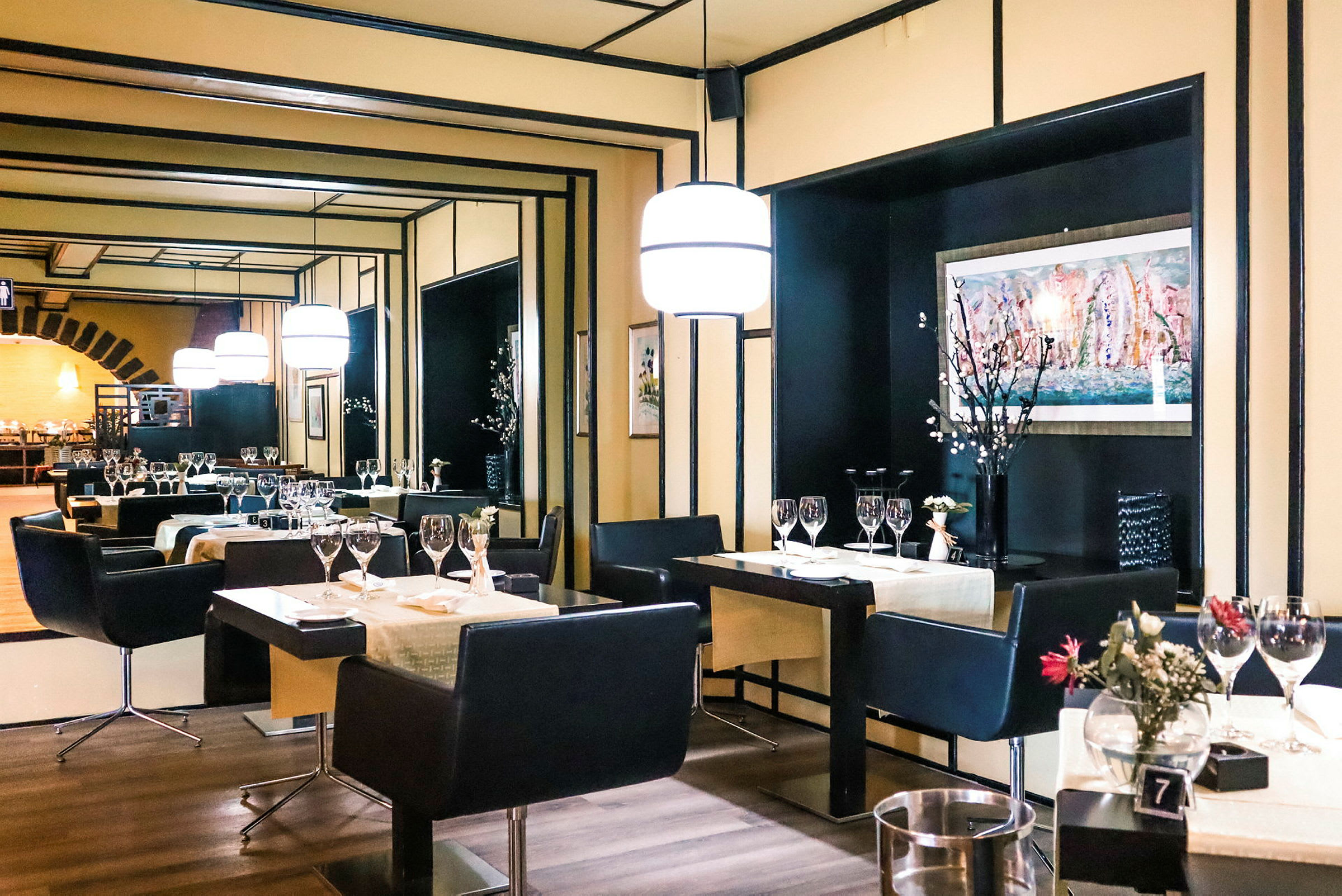 En elegant restaurang med dukade bord, stolar och modern belysning. (AI-genererad text)