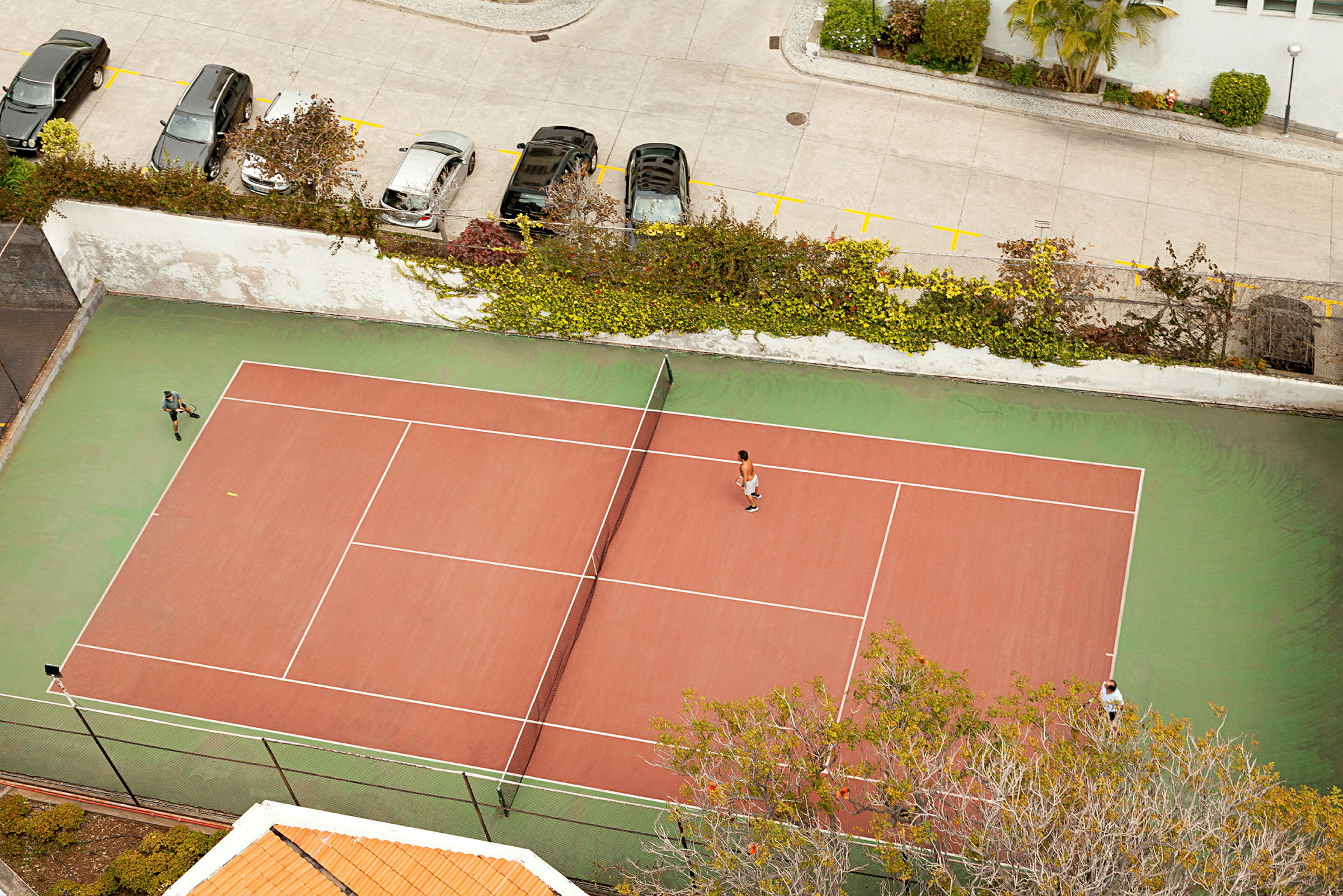 En tennisplan sedd från ovan, med två spelare i spel. (AI-genererad text)