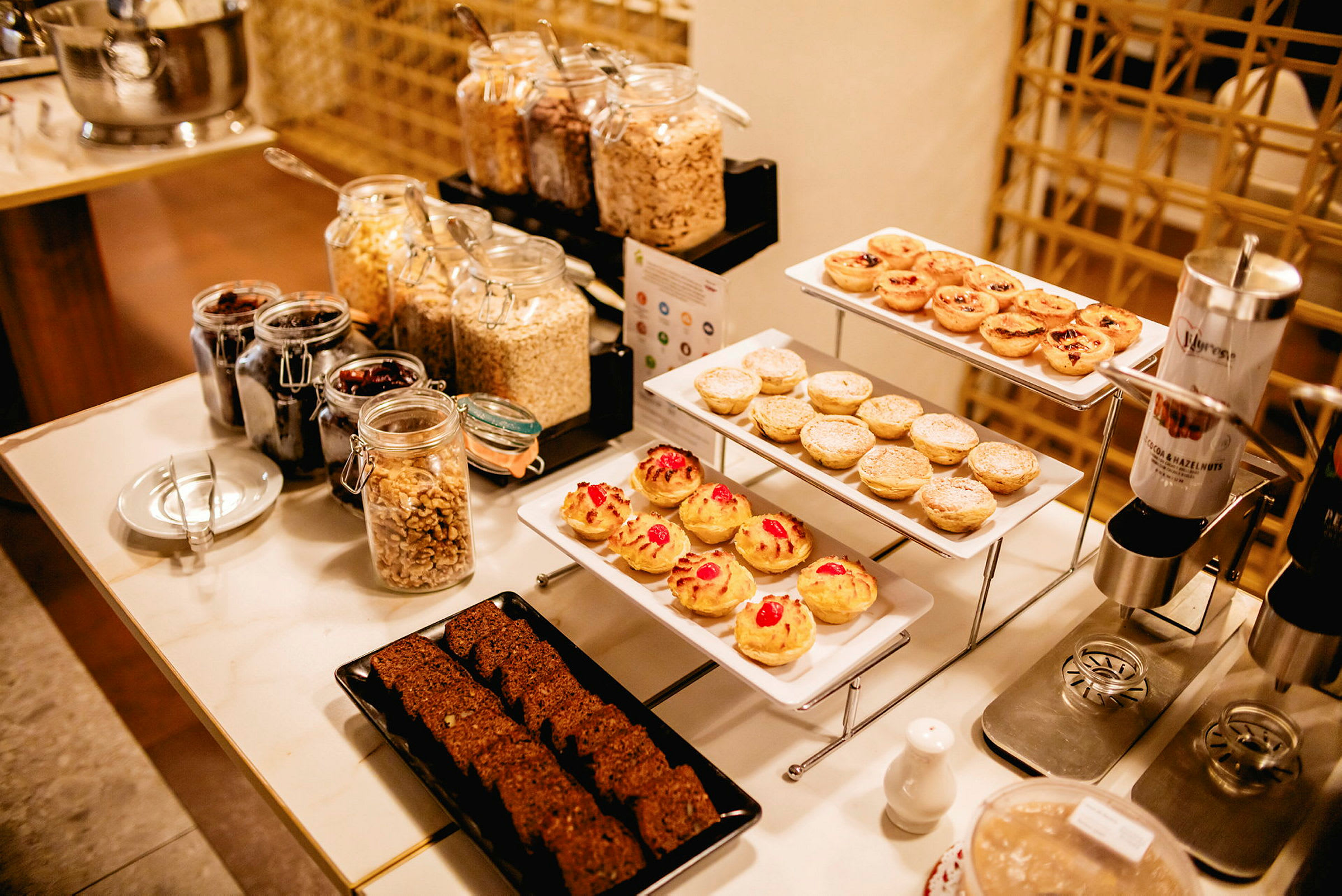 En frukostbuffé med bakverk, frukt och spannmål. (AI-genererad text)